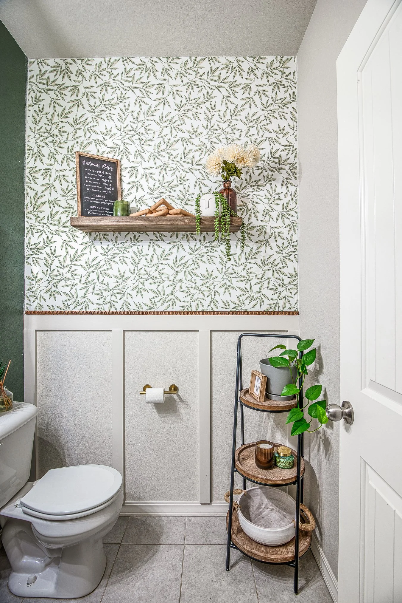 Modern powder room with green botanical wallpaper and white board and batten wainscoting, captured by a local Colorado Springs real estate photographer.