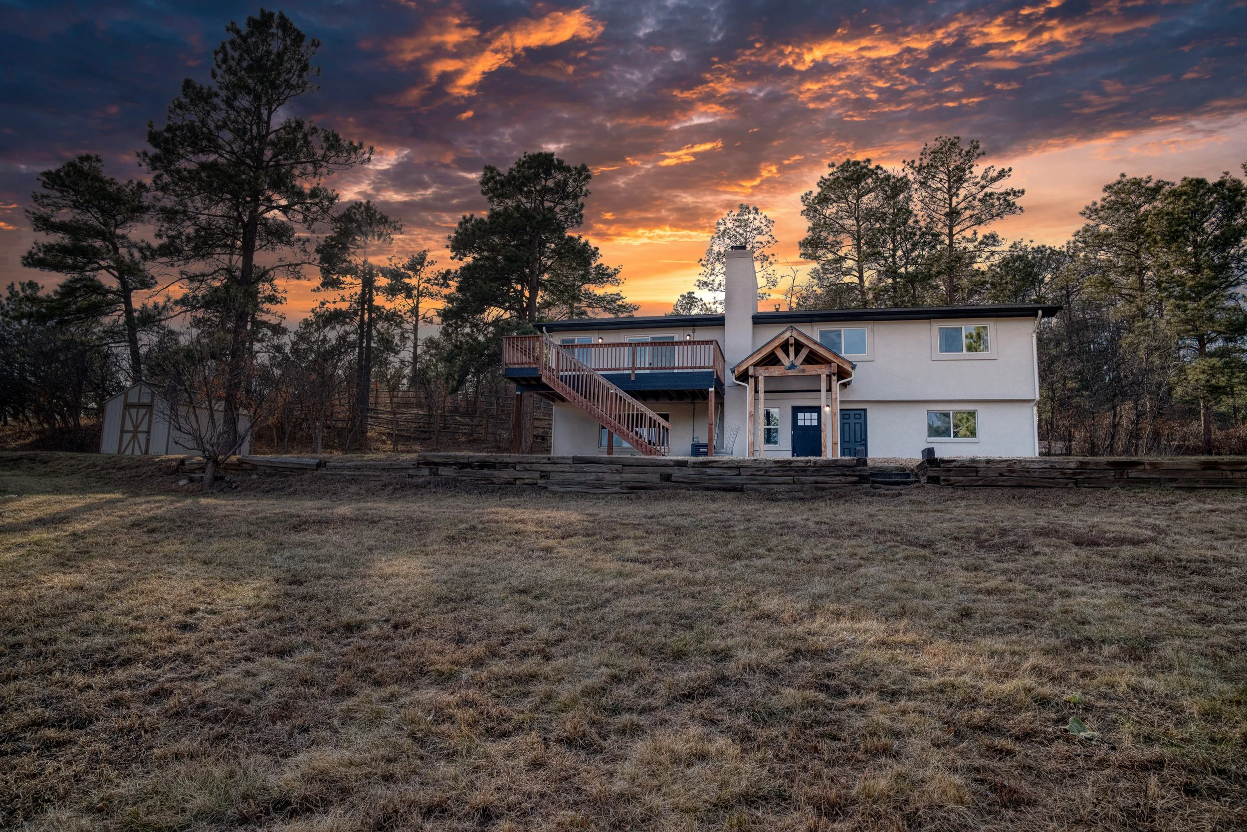 Modern two-story home exterior at sunset featuring a large backyard in Colorado Springs, Colorado.