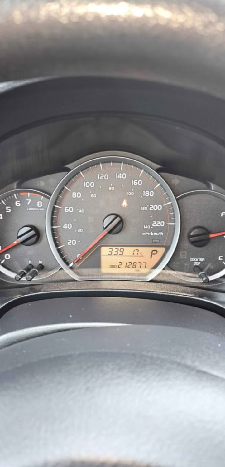 Car dashboard showing speedometer at 0 MPH, tachometer at just below 1,000 RPM, fuel gauge near full, and digital display indicating 339 miles until empty, 17°C, and 21,877 miles driven.