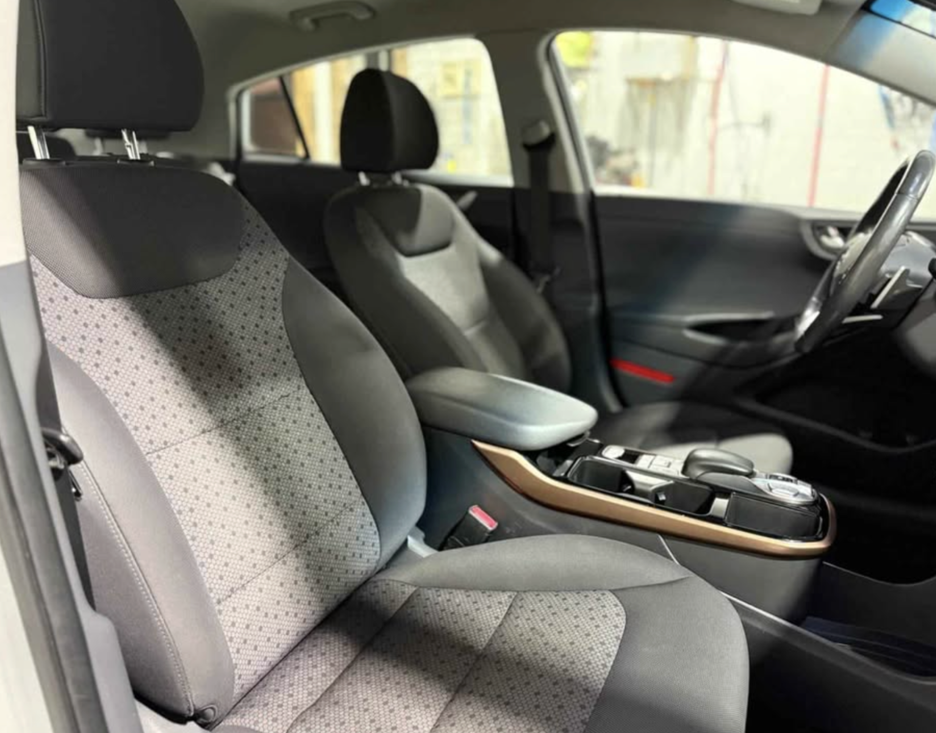 Interior of a modern car showing front seats, steering wheel, and center console.