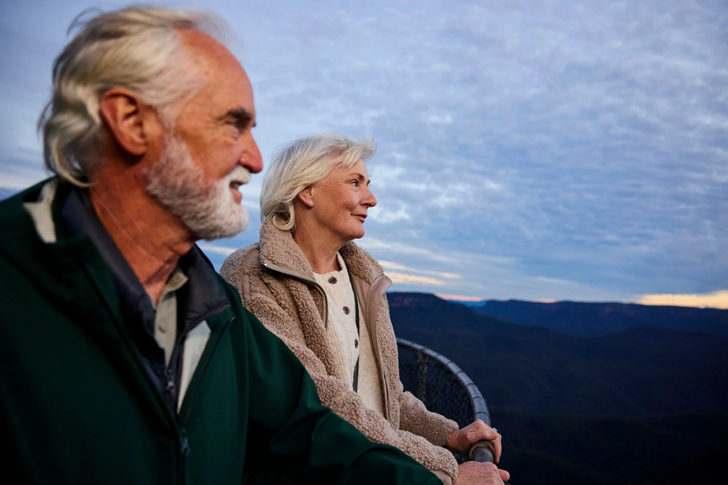 A man & woman with silver hair admire the view from the look-out at Sublime Point, Leura