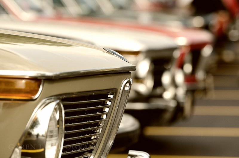 Close-up of classic German cars parked in a row at a vintage car show or lot.