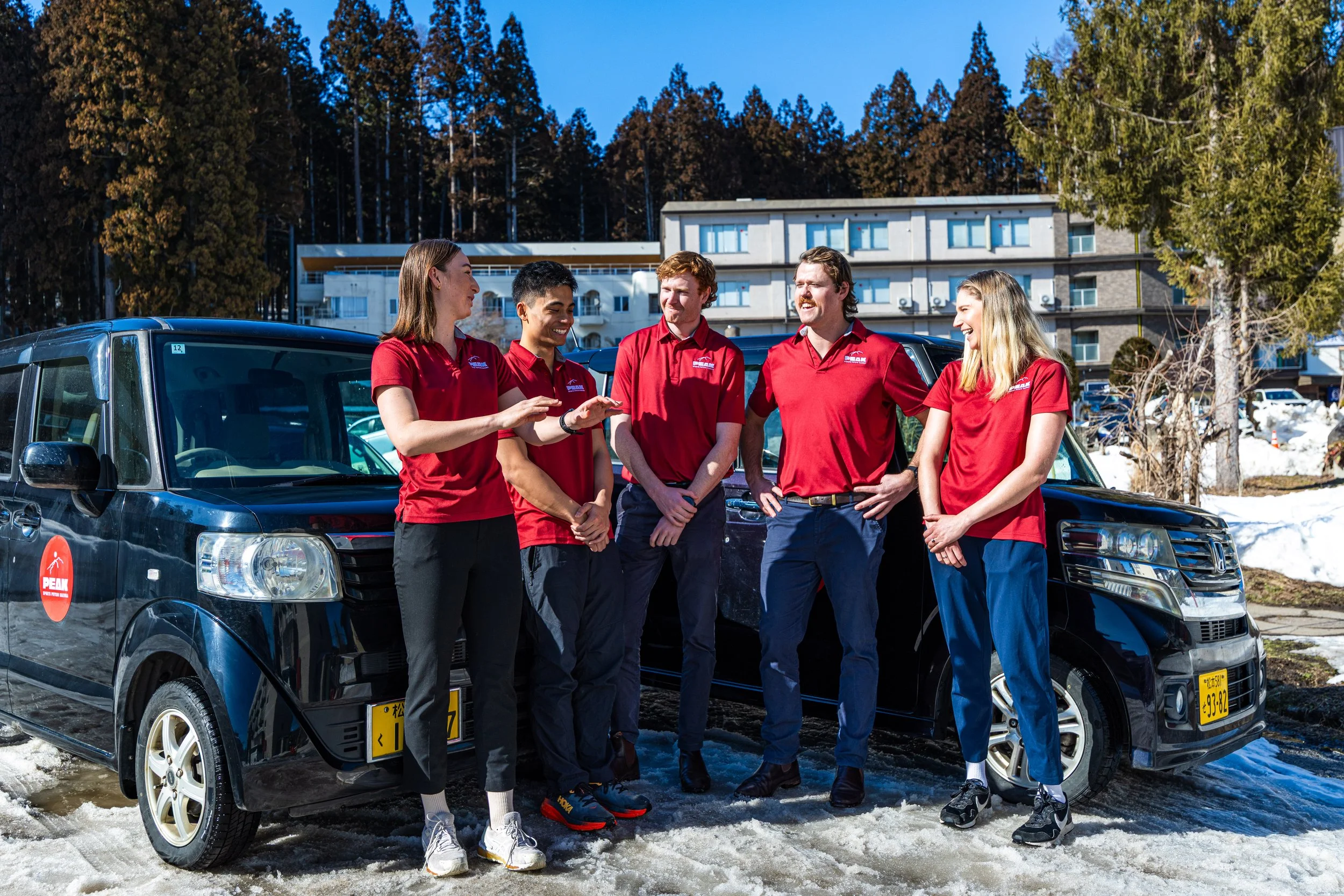 A team of Physio's in Hakuba pose for a photo in front of the Physiotherapy cars