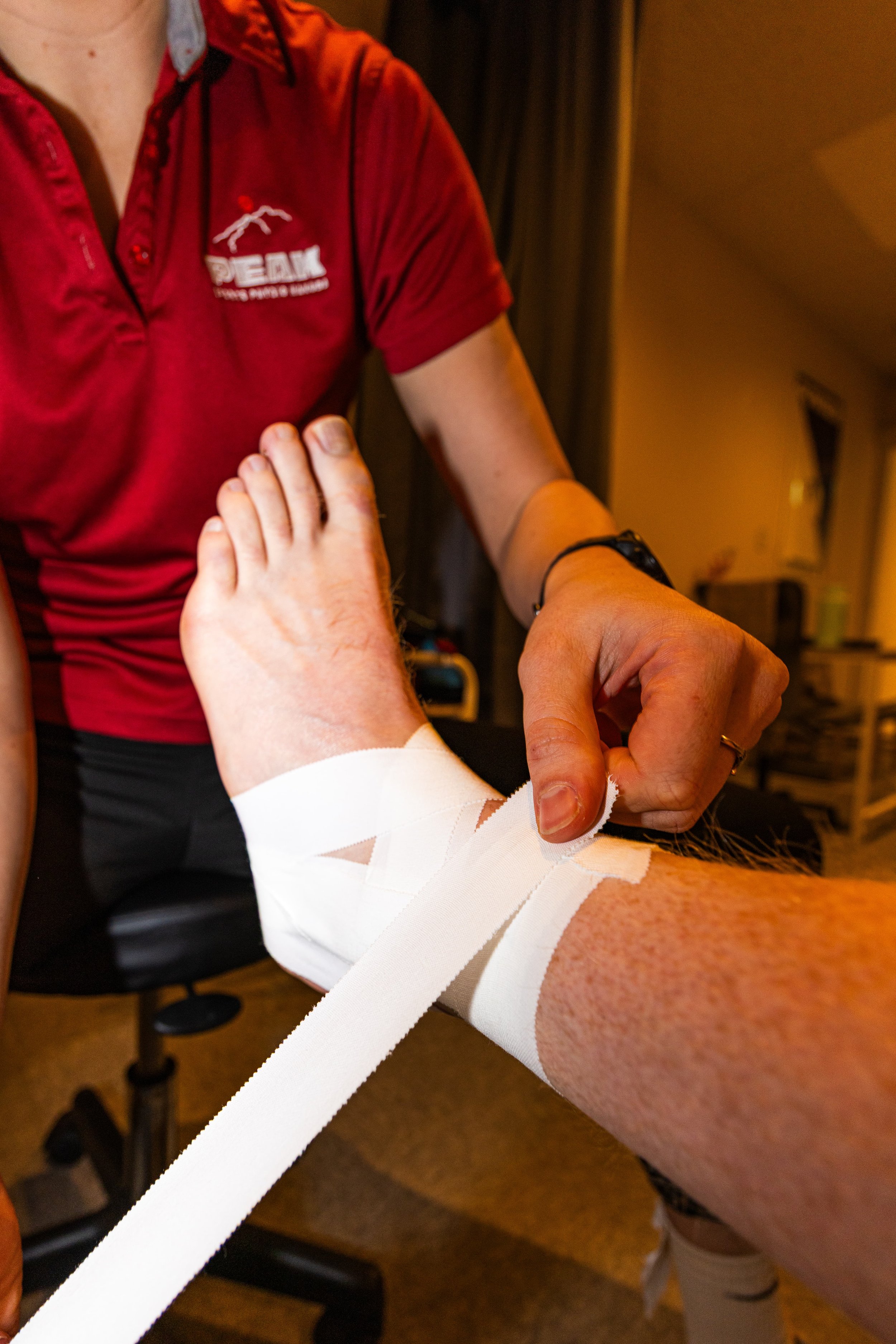 A person with an injured ankle getting treatment and taping from Peak Sports Physio Hakuba