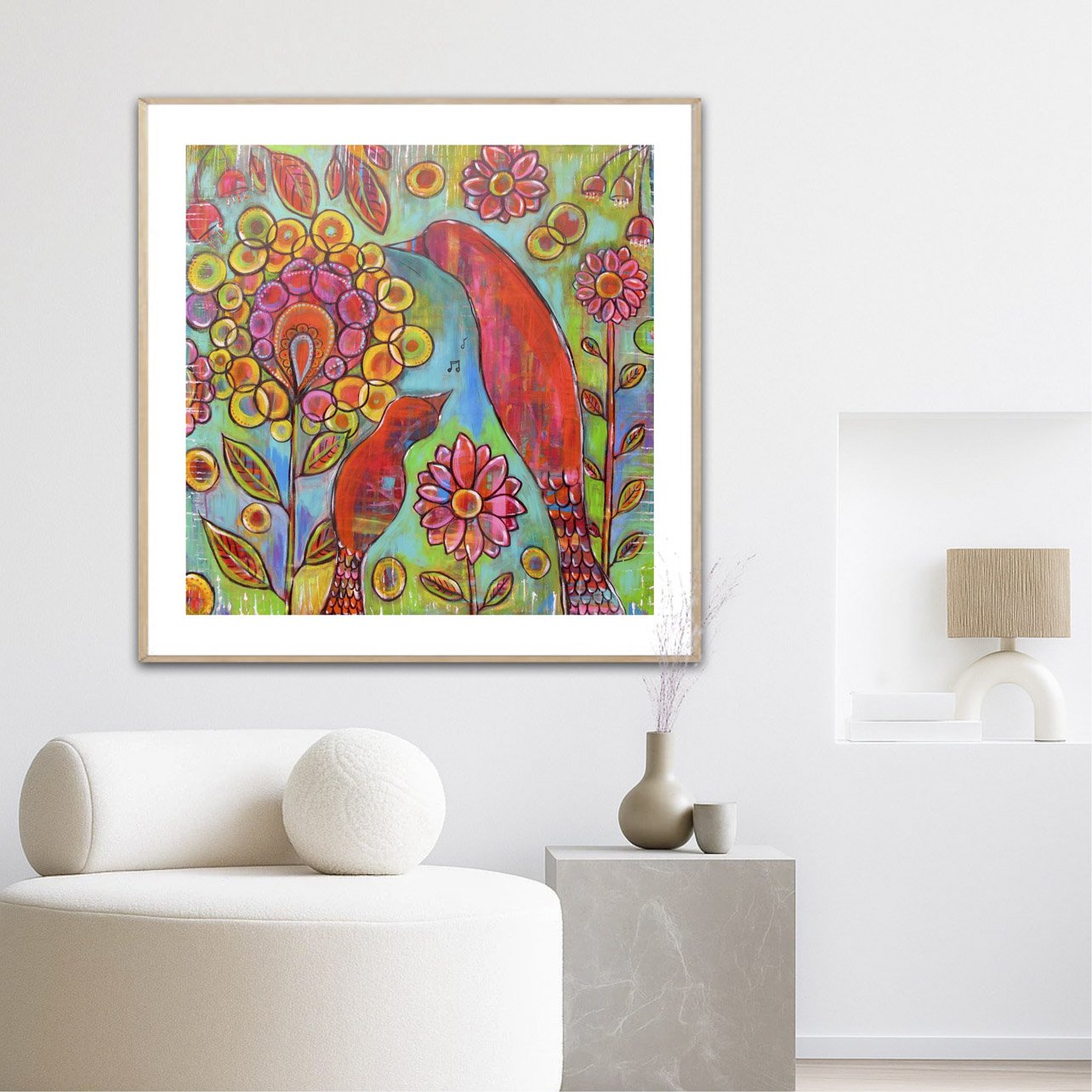 Colorful abstract painting of two birds among flowers, displayed on a white wall in a modern living room.