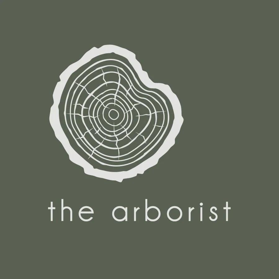 Logo of a tree cross-section with the text "the arborist" beneath it.