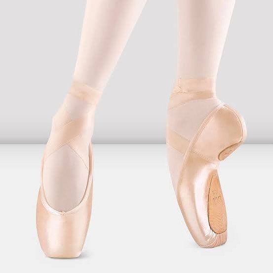 Close-up of ballet dancers' feet in pink pointe shoes, with one foot showing the sole and the other showing the top of the shoe.