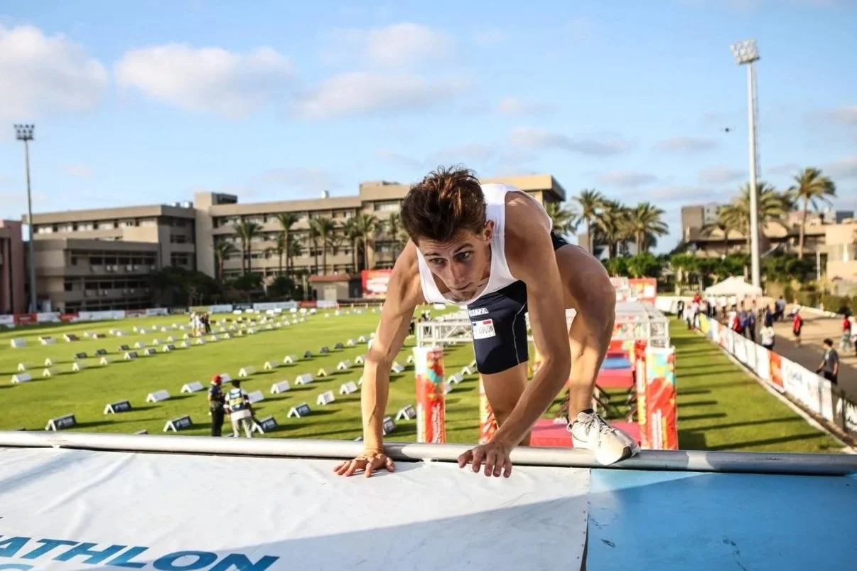 Un homme fait de l'escalade lors d'une compétition d'athlétisme en plein air.