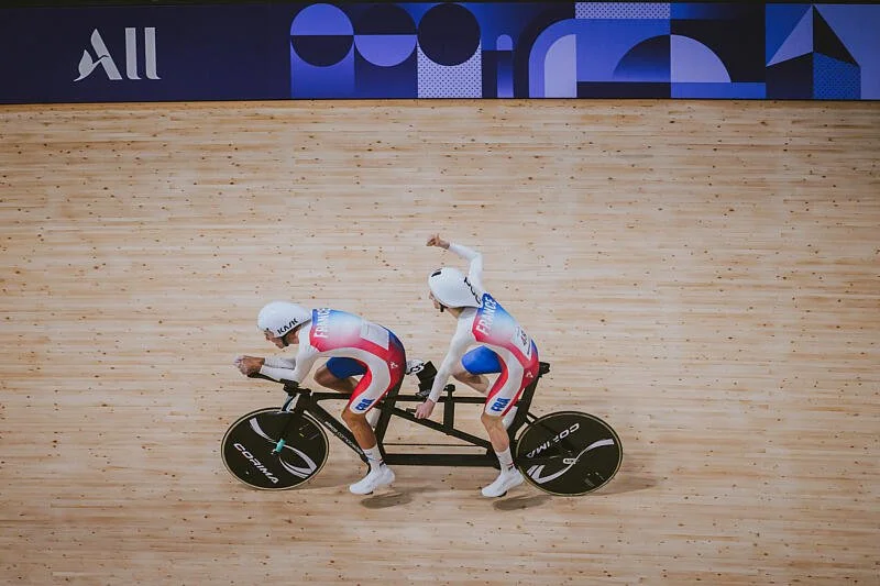 Alexandre lloveras et yohann paillot en tandem sur une piste de velodrome, lors des jeux olympiques de paris 2024 célébrant leur médaille olympique