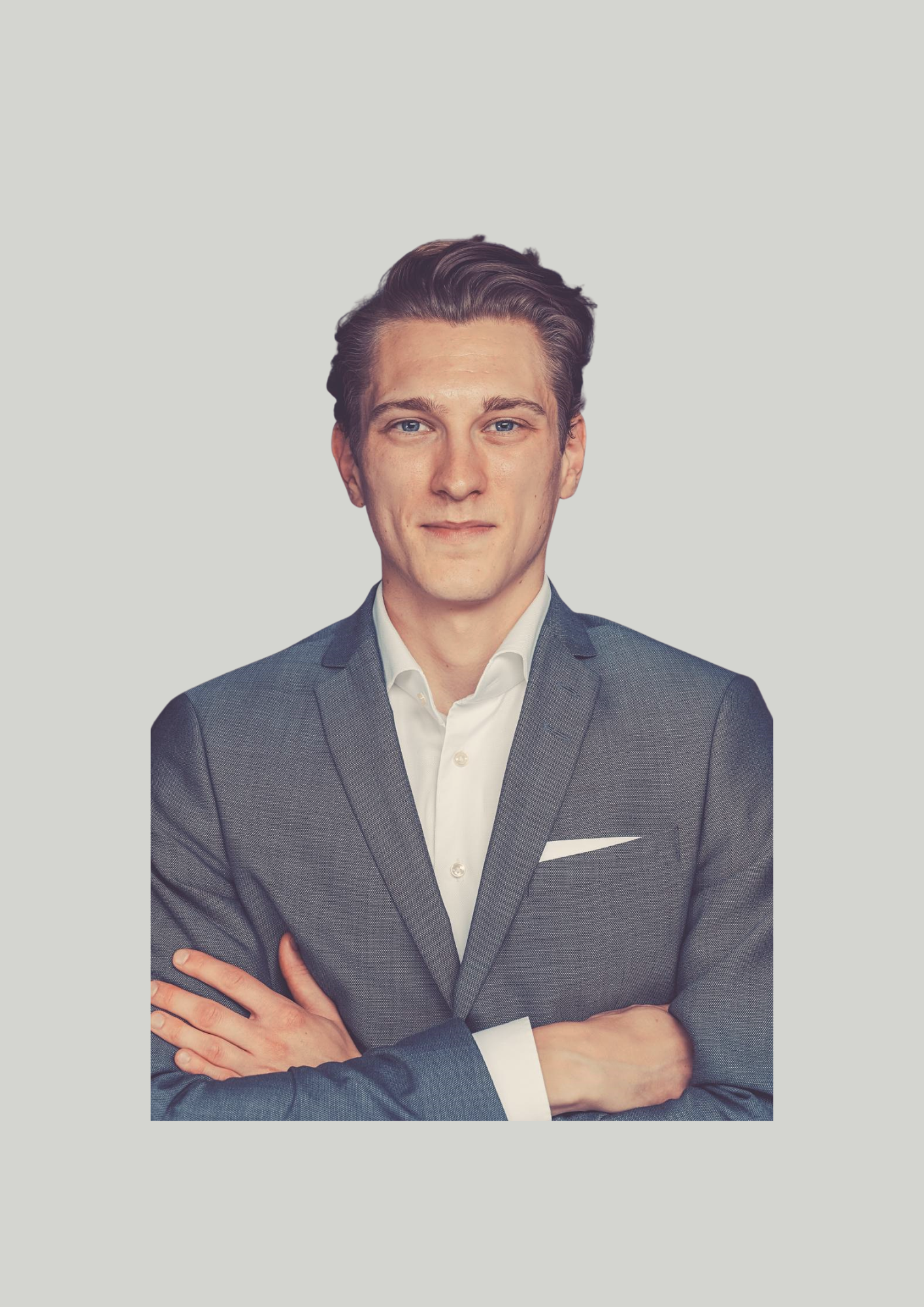 Ein junger Mann in einem grauen Anzug mit weißen Hemd, die Arme verschränkt, vor hellem Hintergrund. Noah Wiegand.