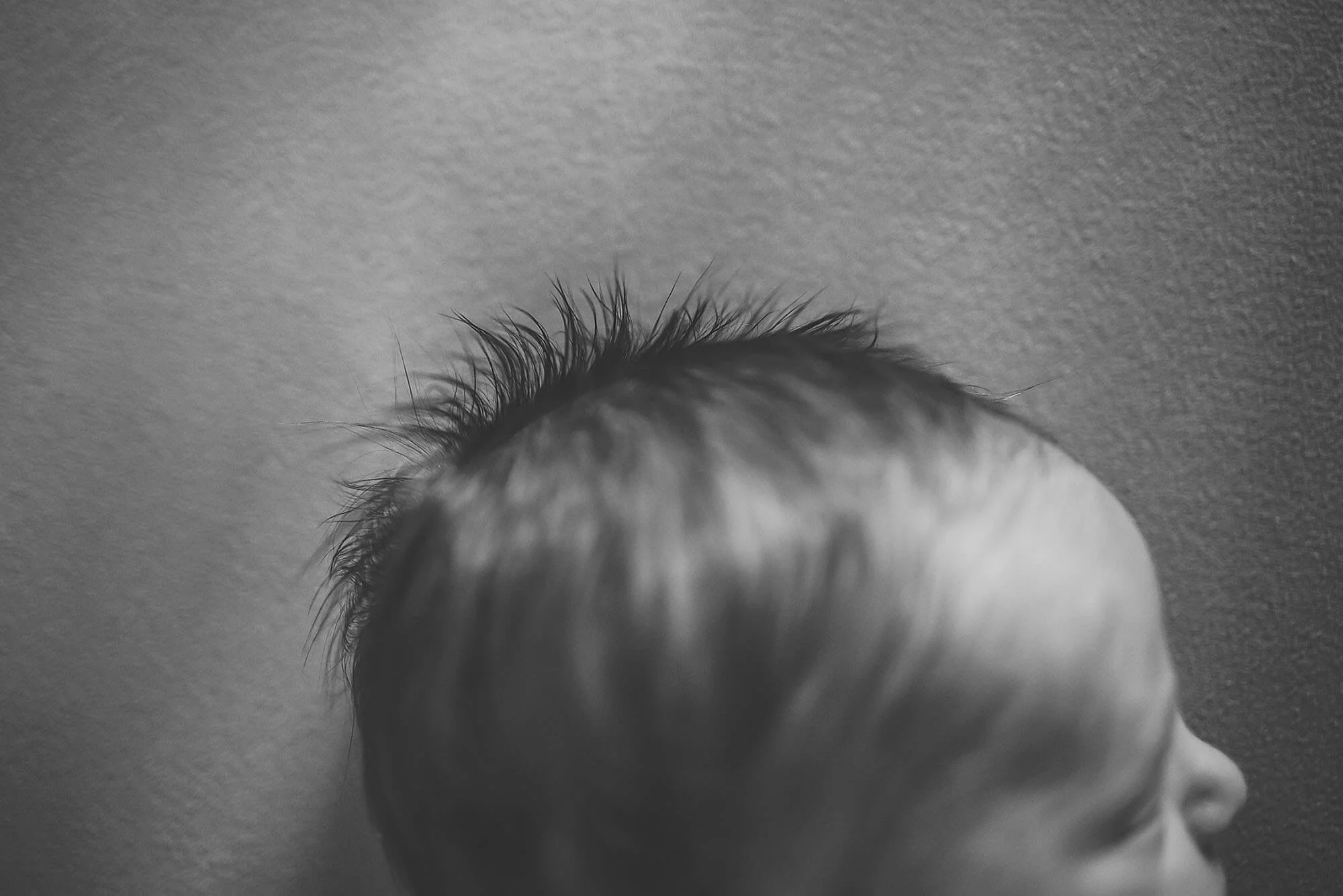 Black and white portrait of a baby's head, highlighting the charm of a new baby during a photography session