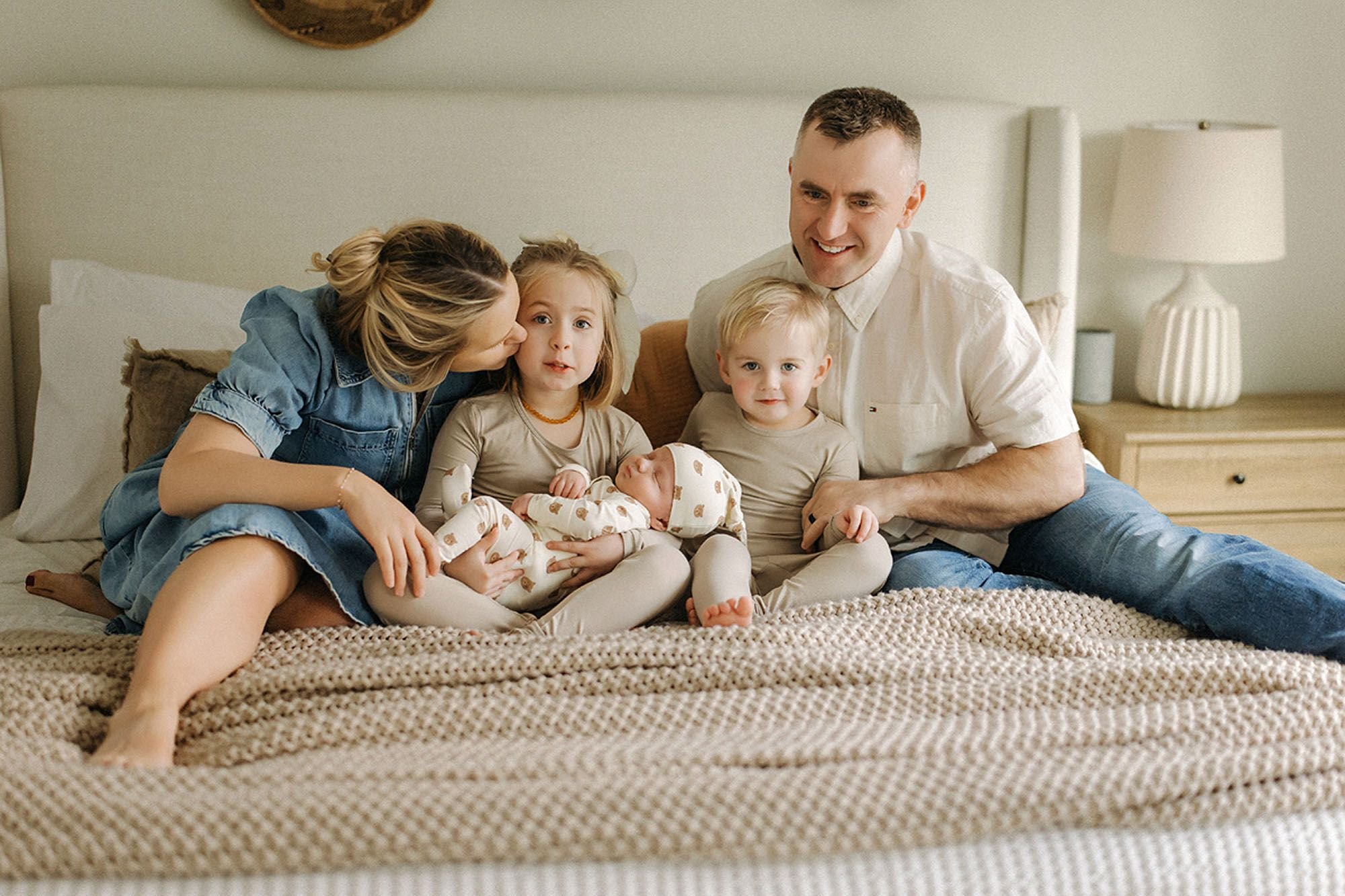 Heartwarming newborn family photography with siblings gently welcoming their new baby while parents share a loving moment, highlighting pro tips for newborn photos with siblings