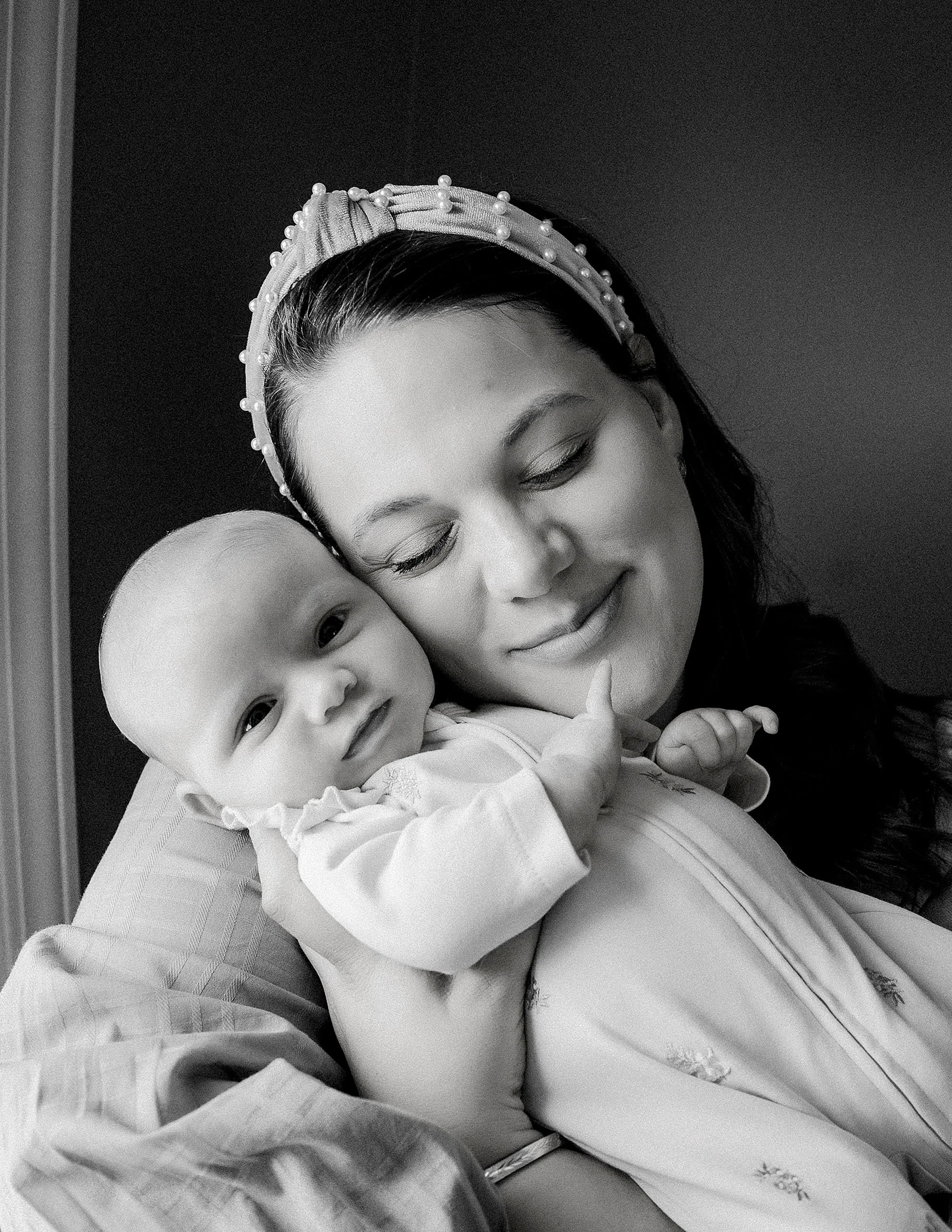 mother cuddling newborn baby in black and white lifestyle portrait
