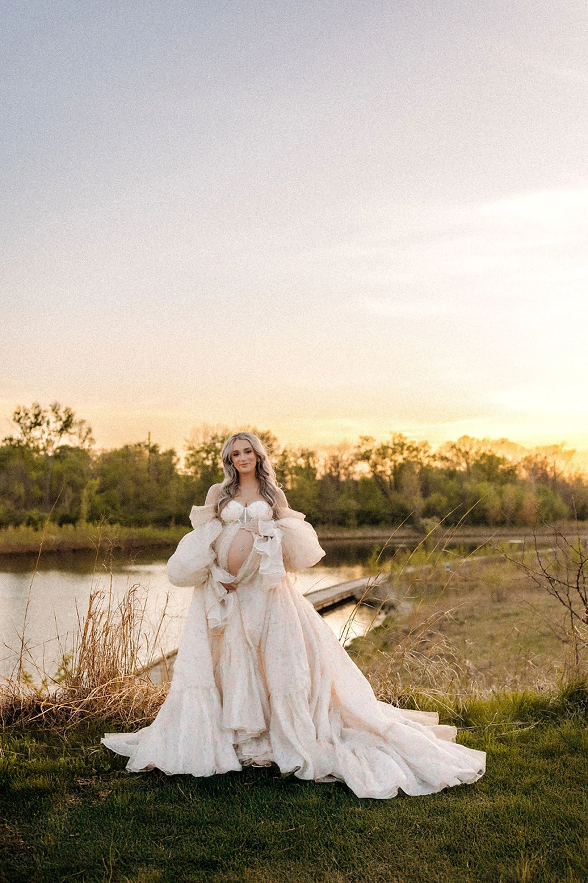 Planning maternity photos in Central Indiana with an elegant outdoor portrait beside the water at golden hour.