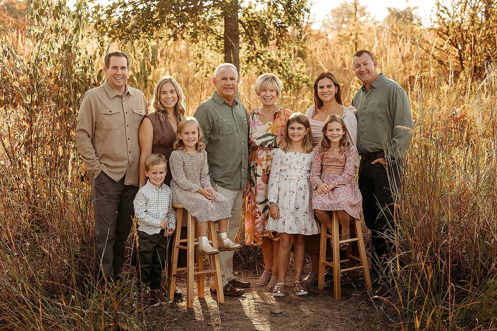 Extended family photography Indianapolis with large family group smiling in golden grass field