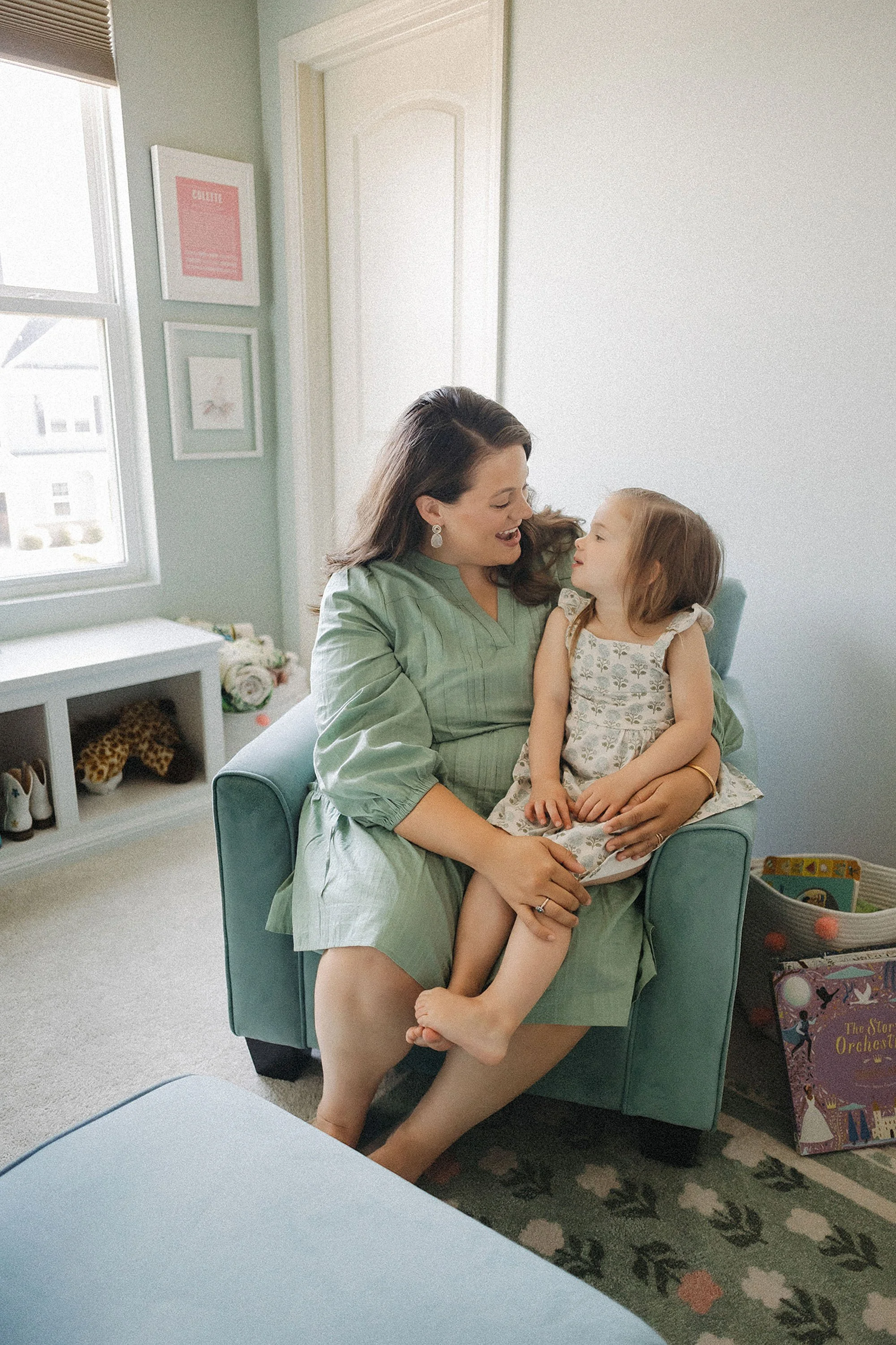  parent sitting with toddler during newborn lifestyle photography session at home 