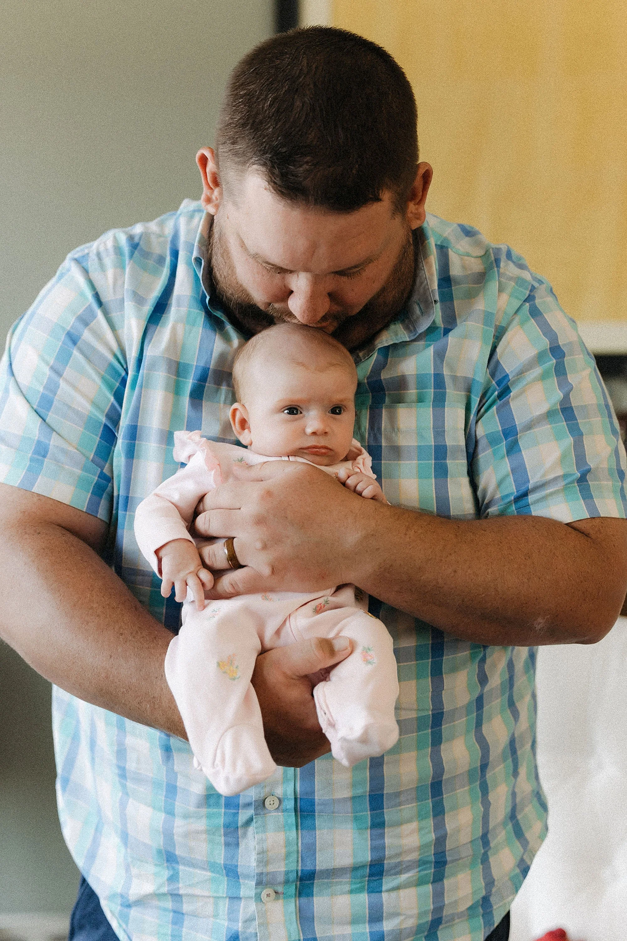  father holding newborn baby during in-home lifestyle photography session 