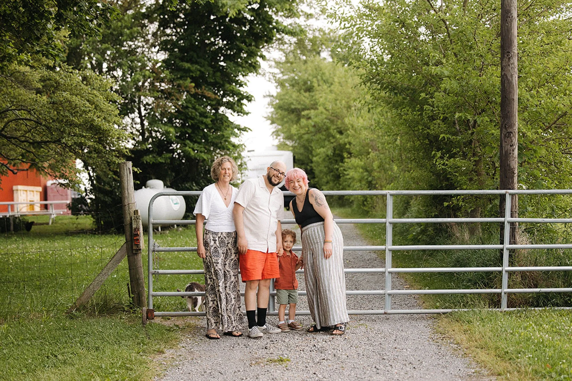 Heavenly Acres Farm family portrait featuring three generations smiling together at the farm gate, creating a warm and authentic countryside memory