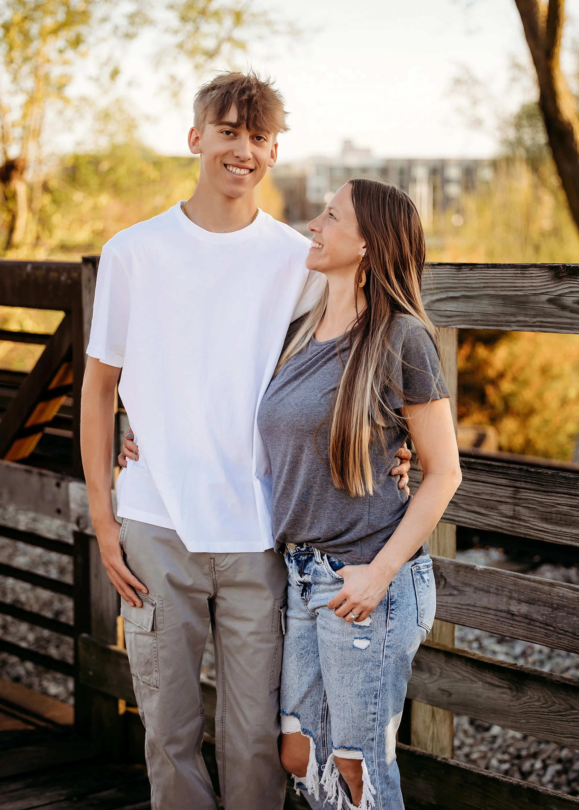A young man stands confidently in an alleyway, captured during his senior photo session in downtown Noblesville