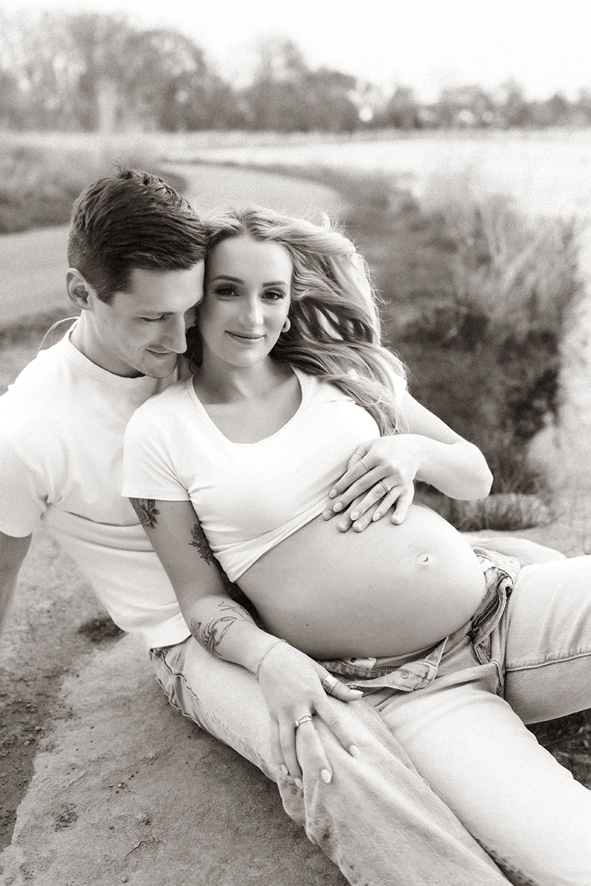 Expectant mother in a flowing white maternity gown during a dreamy Central Indiana lakeside maternity photo session.