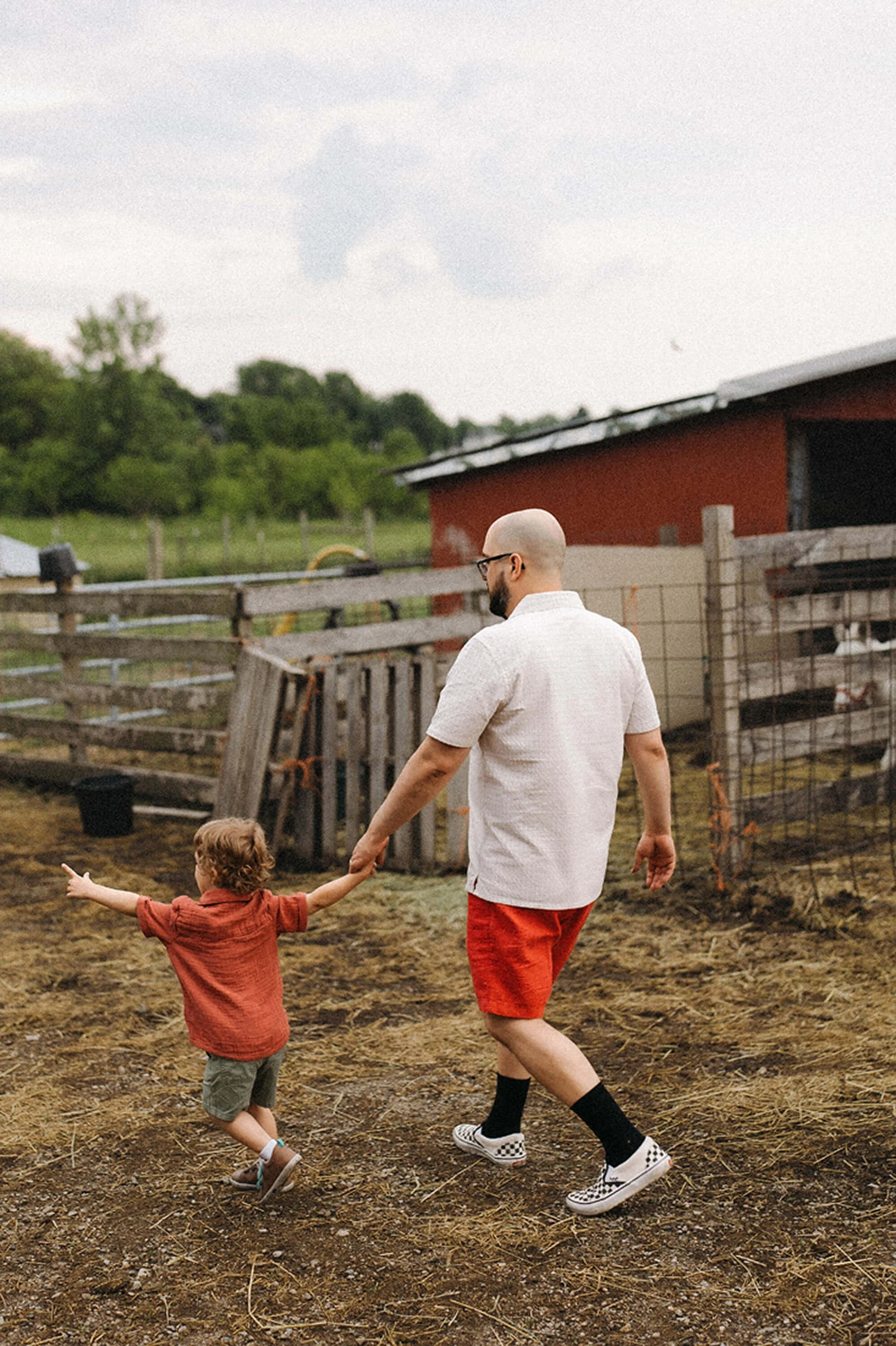 A family explores the peaceful grounds of Heavenly Acres Farm, enjoying a hands-on countryside experience surrounded by animals and rustic farm buildings