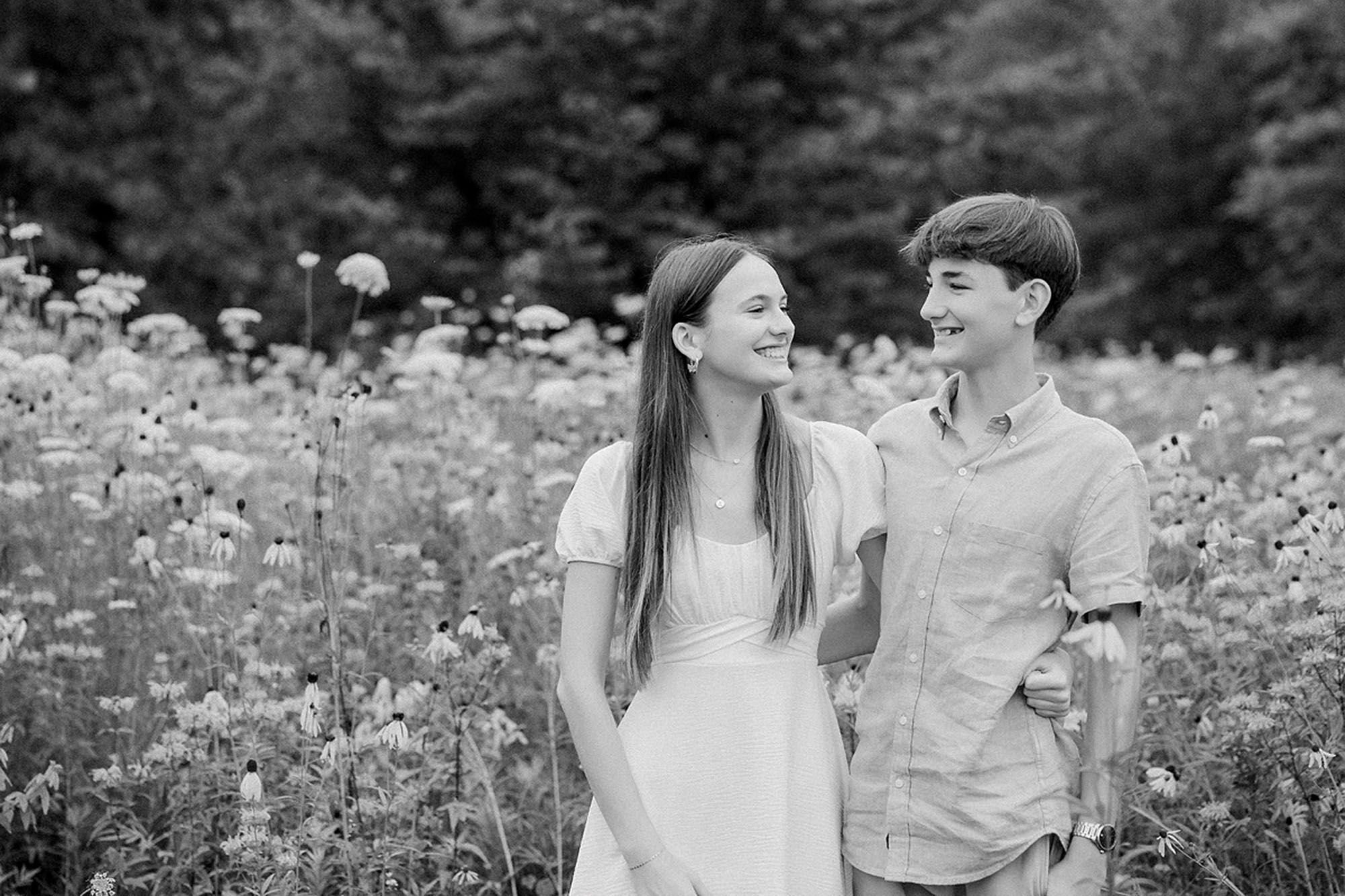 Teenage siblings laughing together during a summer extended family photo session.