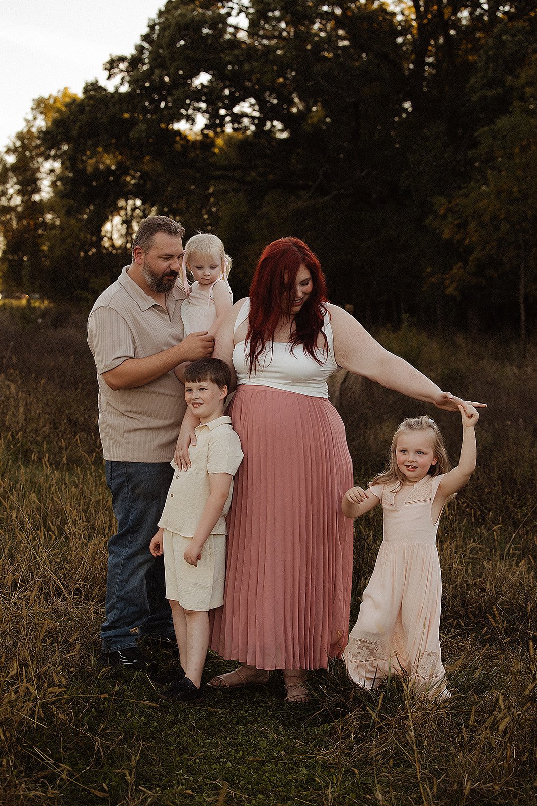Family photography in Indianapolis with parents with three children smiling outdoors at sunset