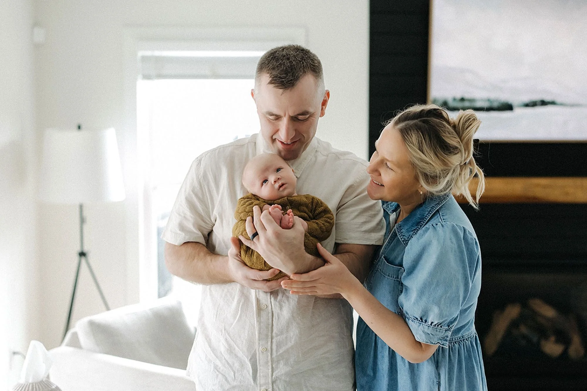 Beautiful in-home newborn family photography featuring loving parents holding their baby in soft natural light, capturing family bonding, heartfelt emotions, and timeless lifestyle newborn portraits with expert newborn photography tips