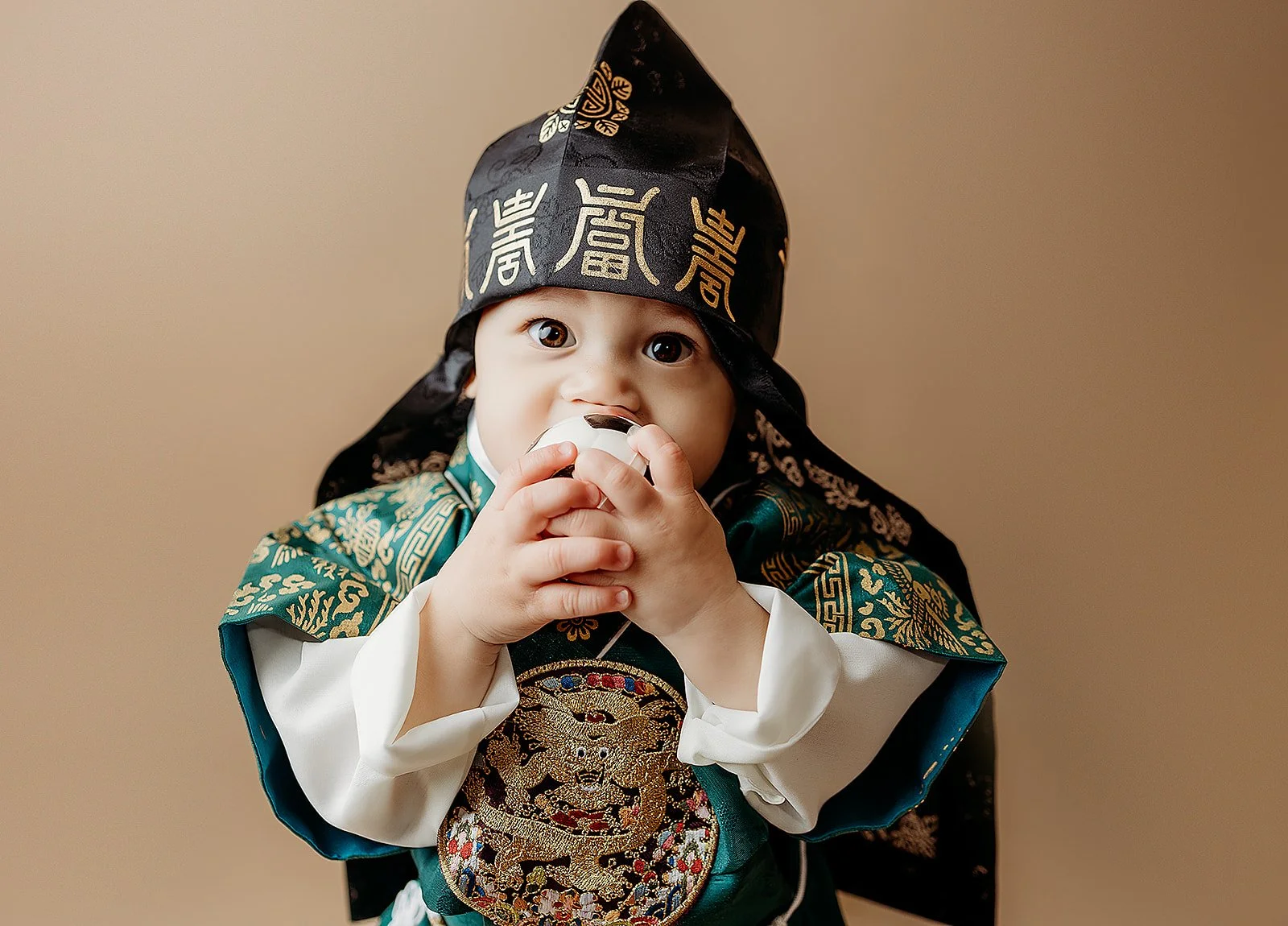 Milestone photography Indianapolis with baby in traditional outfit holding toy