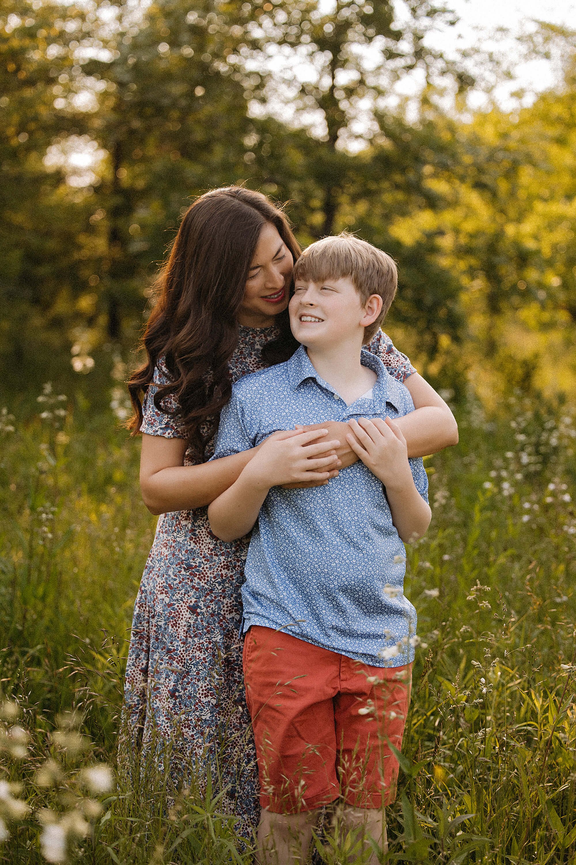 A family captures a moment in the woods, dressed in colorful spring clothing, surrounded by blooming trees and greenery