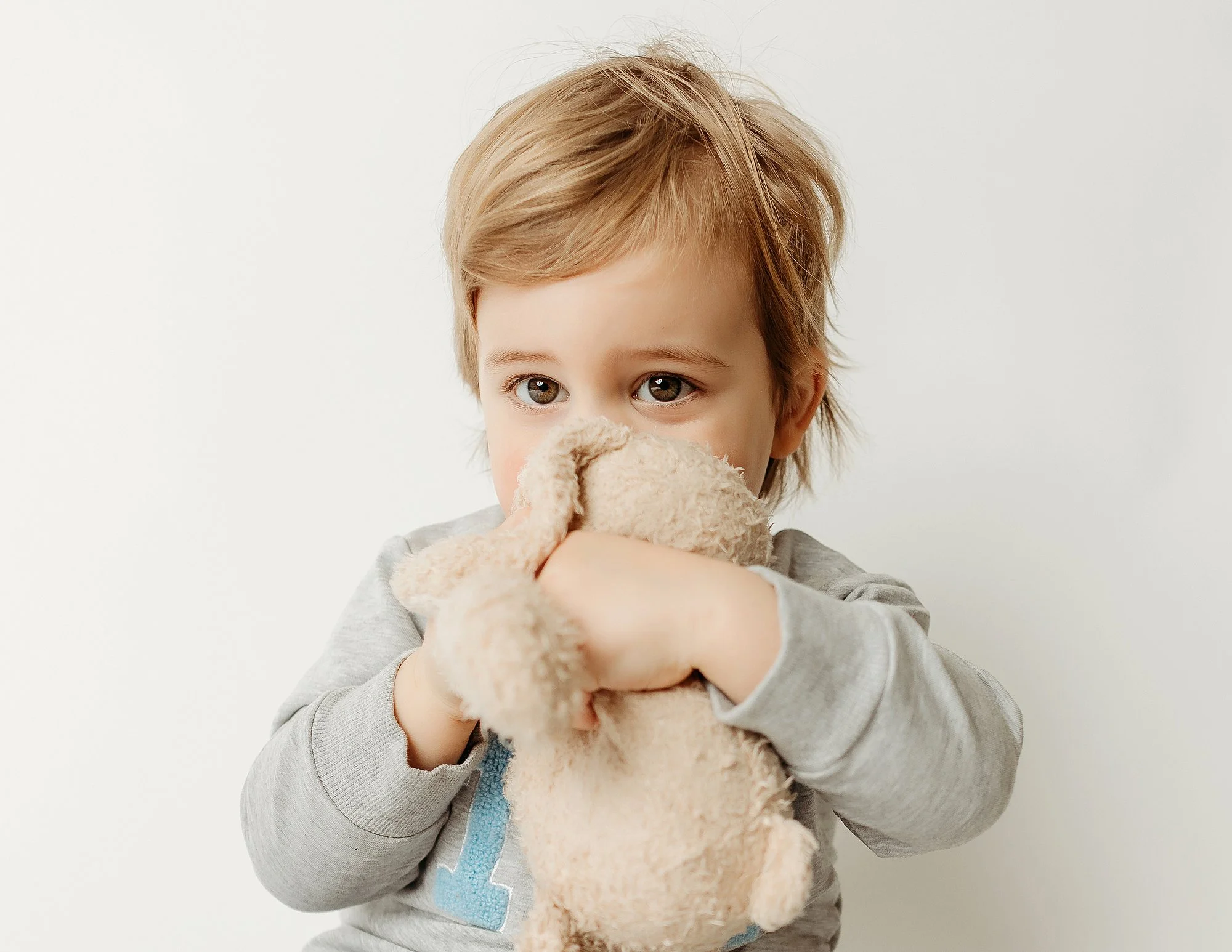 Toddler holding a favorite lovey during a calm and comfortable studio portrait session