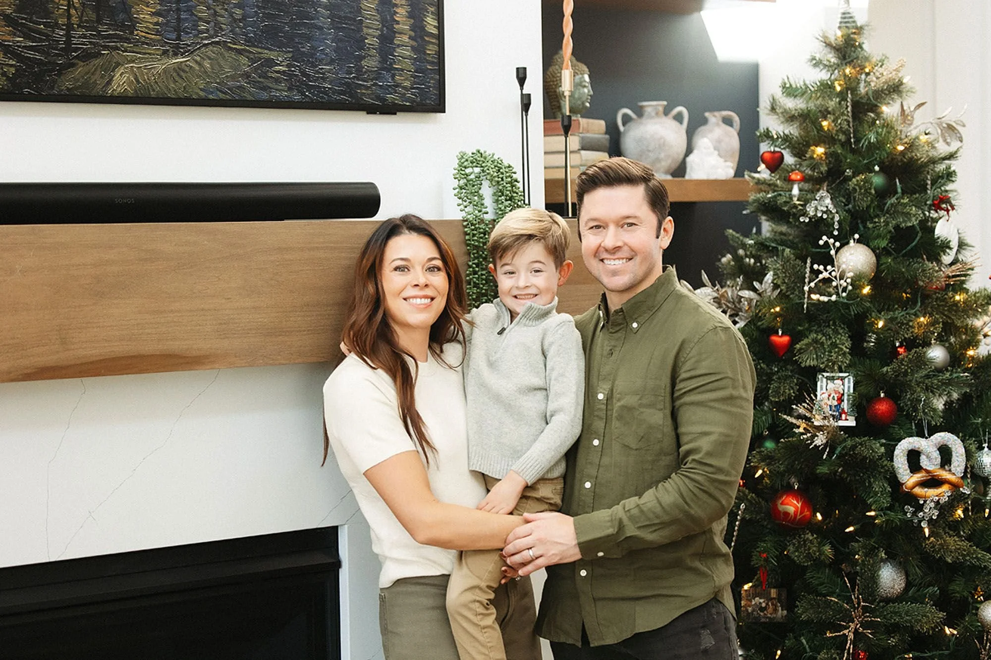 Smiling family posing beside a beautifully decorated Christmas tree, capturing the warmth and timeless style of Christmas Tree Farm Photos in Central Indiana