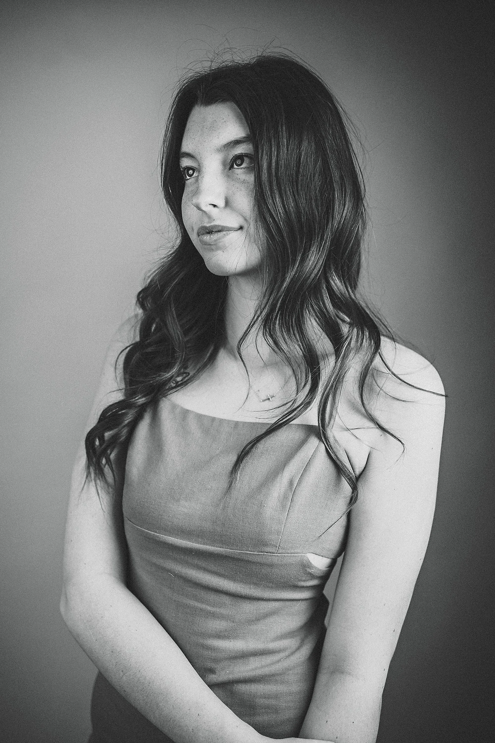 Black and white studio senior portrait in Indianapolis featuring college hoodie and minimalist lighting