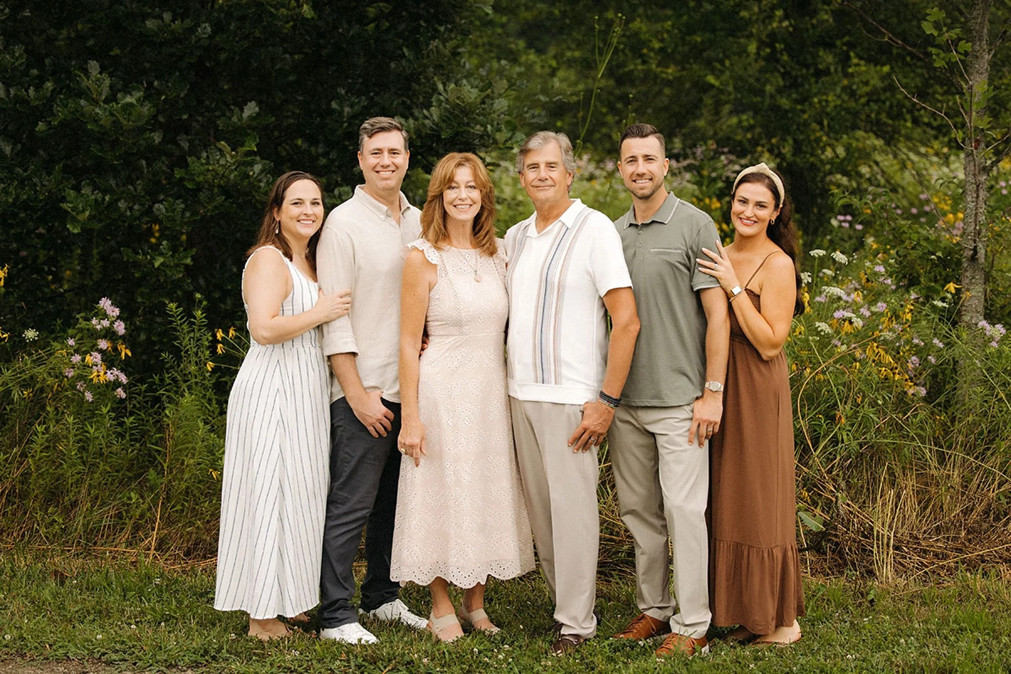 Adult siblings standing together with their parents during a summer family photo session in Westfield, Indiana.