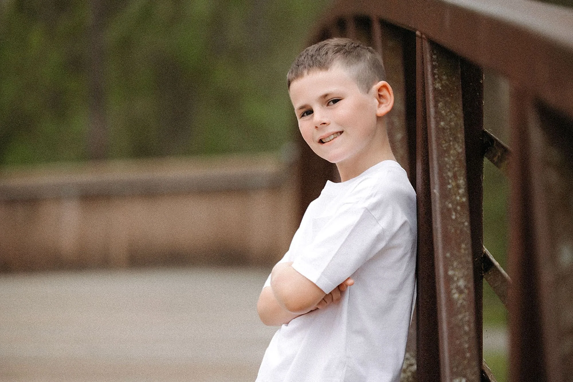 Smiling teenage boy posing confidently outdoors, showing how to prepare kids for family photos with a relaxed and comfortable mindset