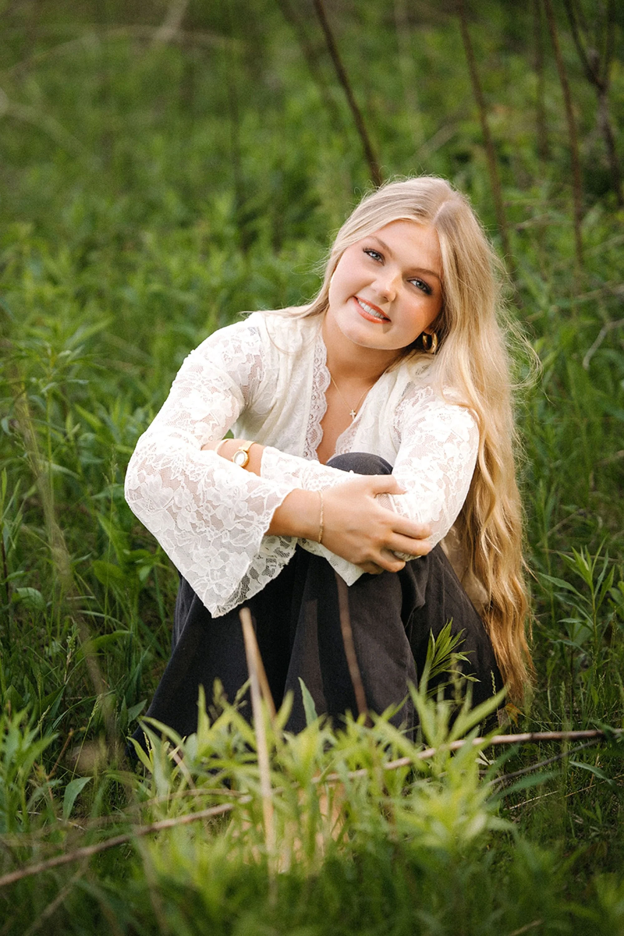 Outdoor Hamilton Heights Senior Photos featuring a blonde graduate embracing the beauty of nature with a relaxed pose and classic senior portrait style