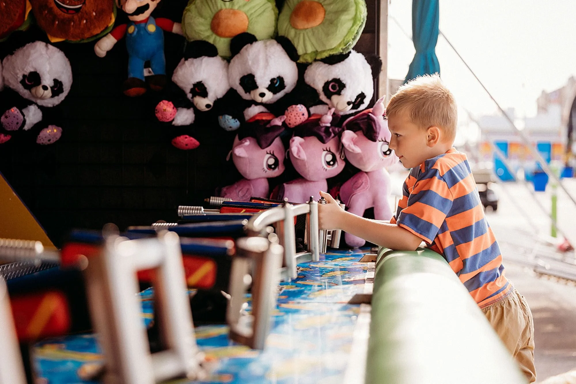 Young boy playing a carnival game at an Indiana fair, capturing fun Carnival Lights and Family Photos in Indiana