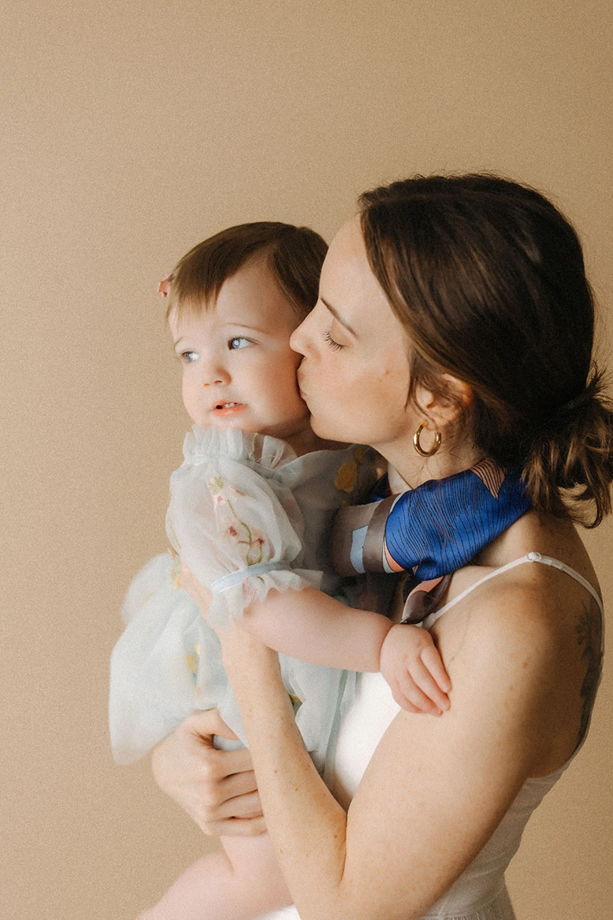 Simple Cake Smash Photos capturing a sweet mother-and-daughter moment with a little girl in a delicate white dress, perfect for a timeless first birthday celebration.