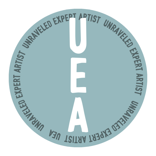 A circular logo with the word 'UEA' in large white letters vertically in the center. Surrounding it is a ring of text that says 'Unraveled Expert Artist' repeatedly on a light blue background.