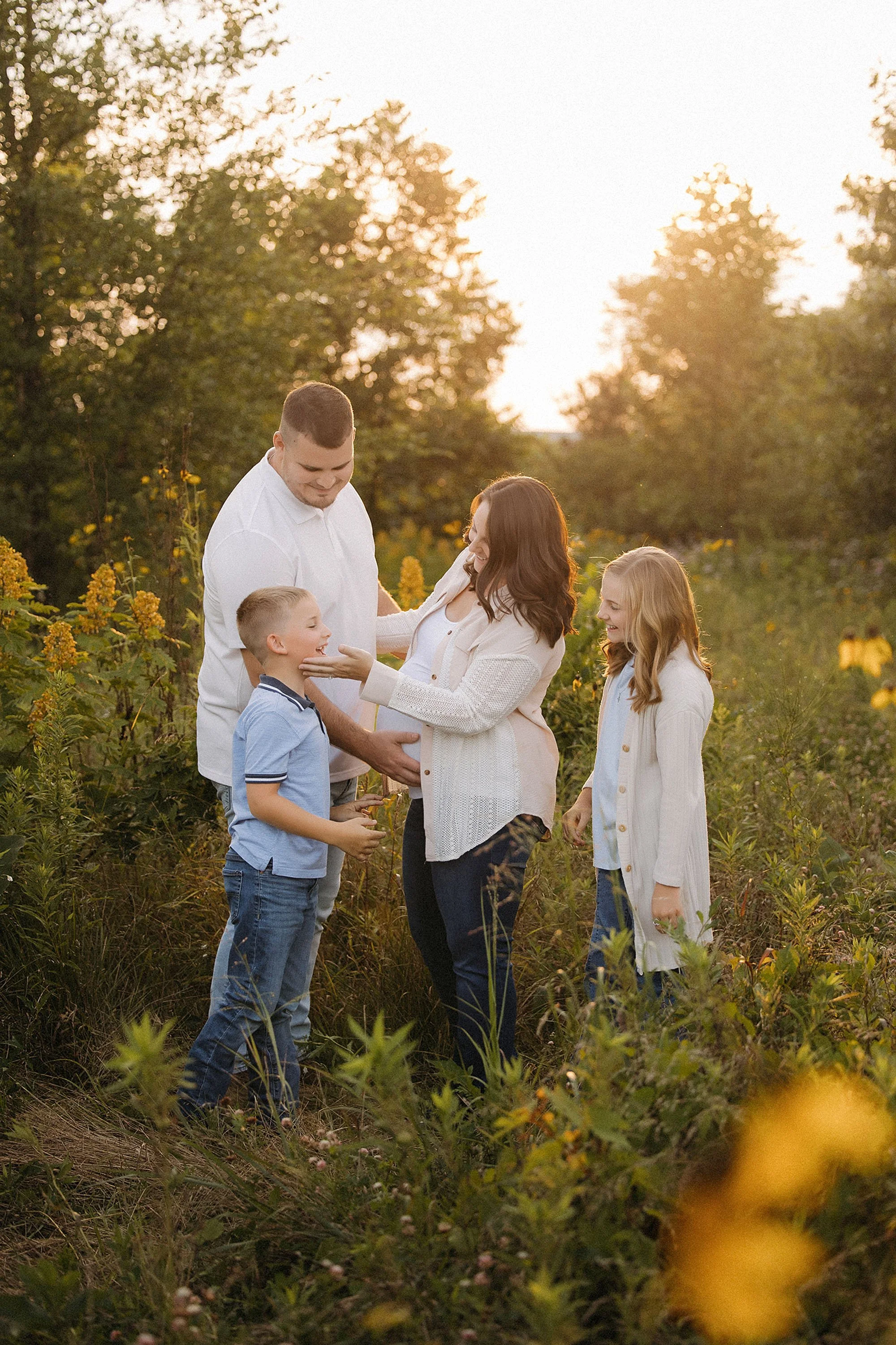 Pregnant mom interacting with her children during a relaxed outdoor maternity session in Indiana