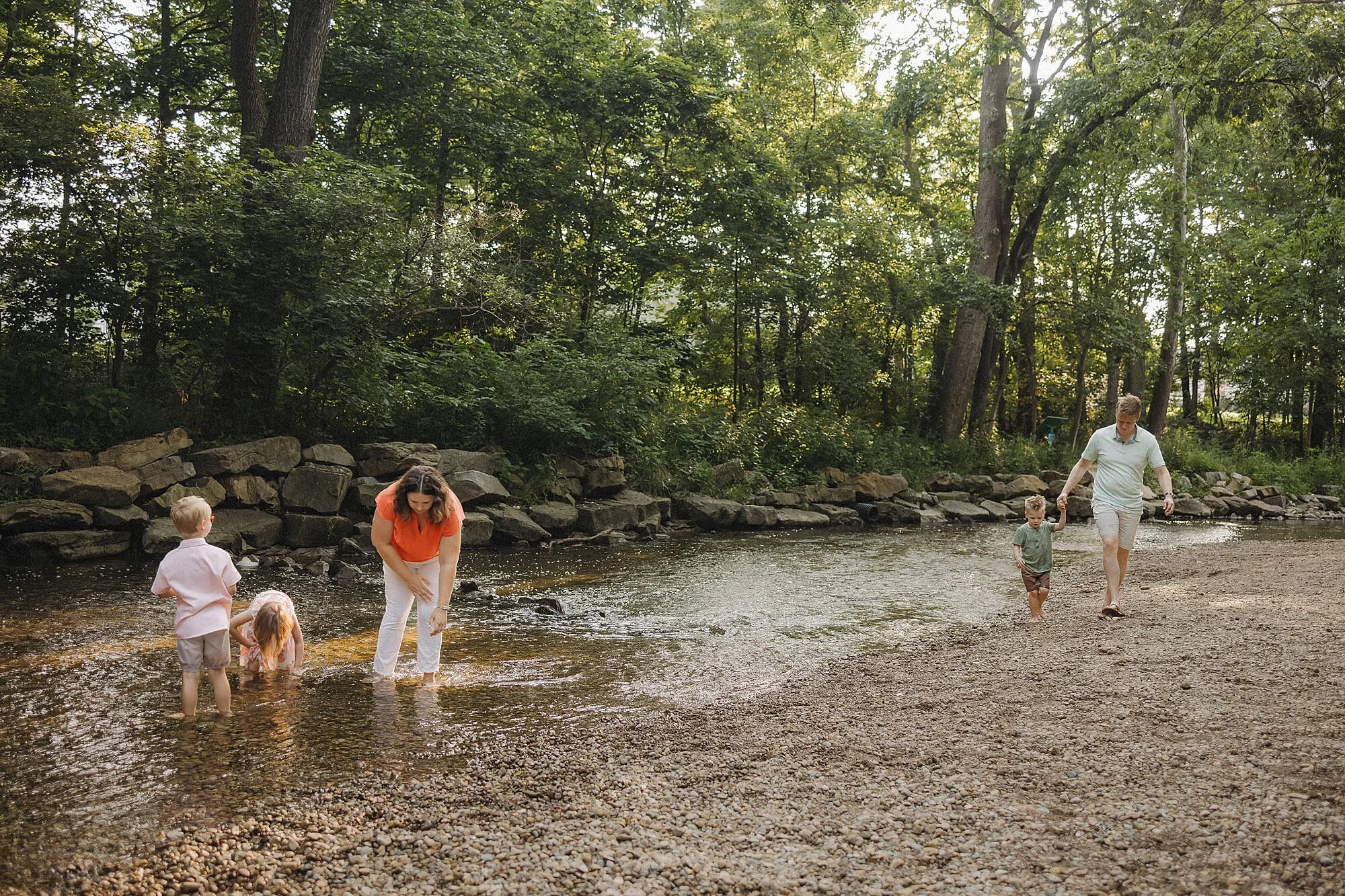 A family of four having fun in the river, celebrating a warm spring day with laughter and play