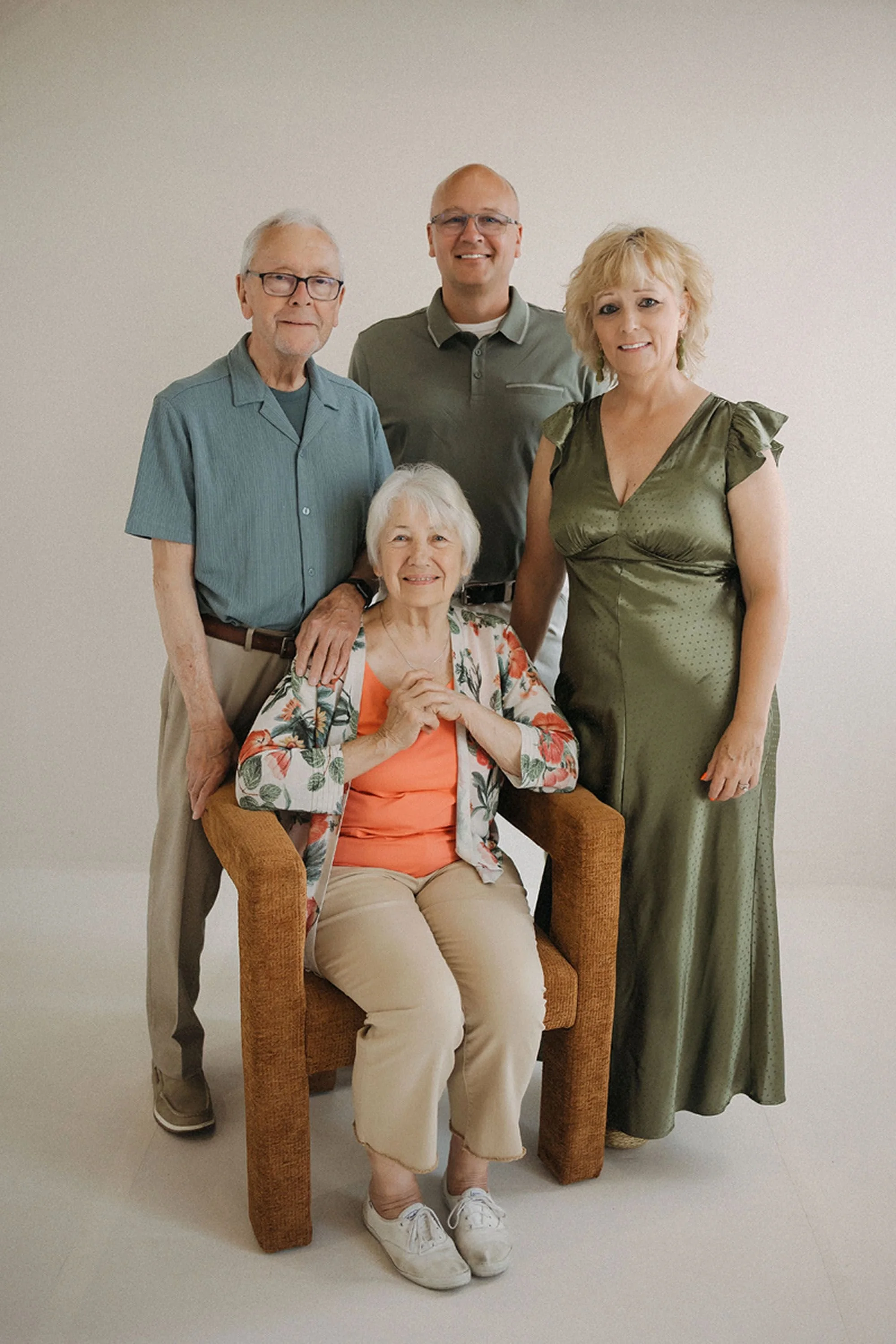 Multi-generational family posing together in a bright, minimalist studio, with grandparents and adult children smiling for timeless Studio Family Photos at Studio Loft 18.