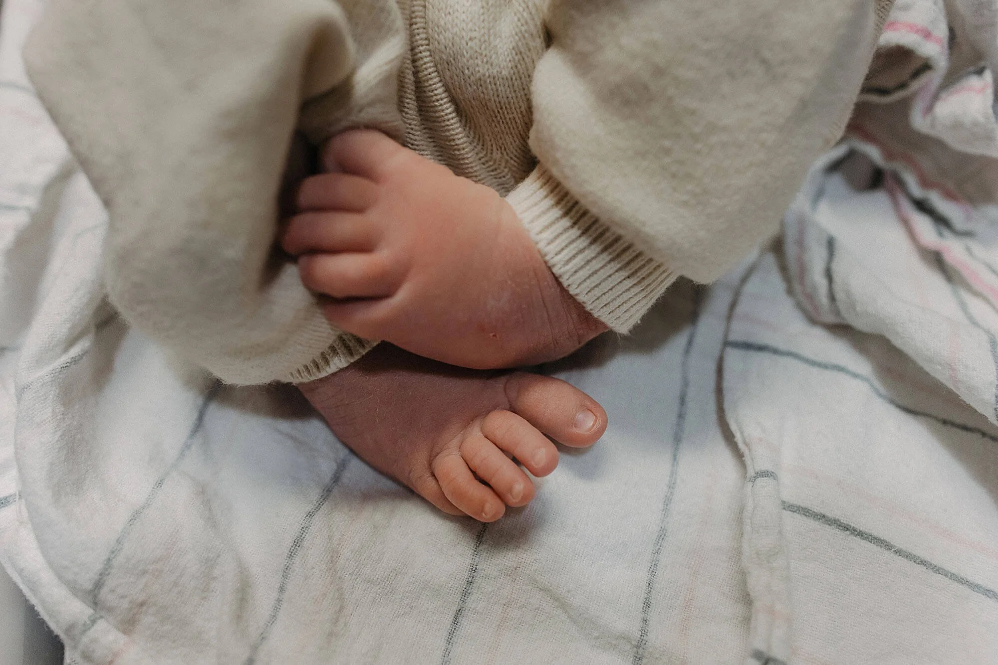 A close-up of a newborn baby's feet, showcasing delicate toes in a hospital during a Fresh 48 session