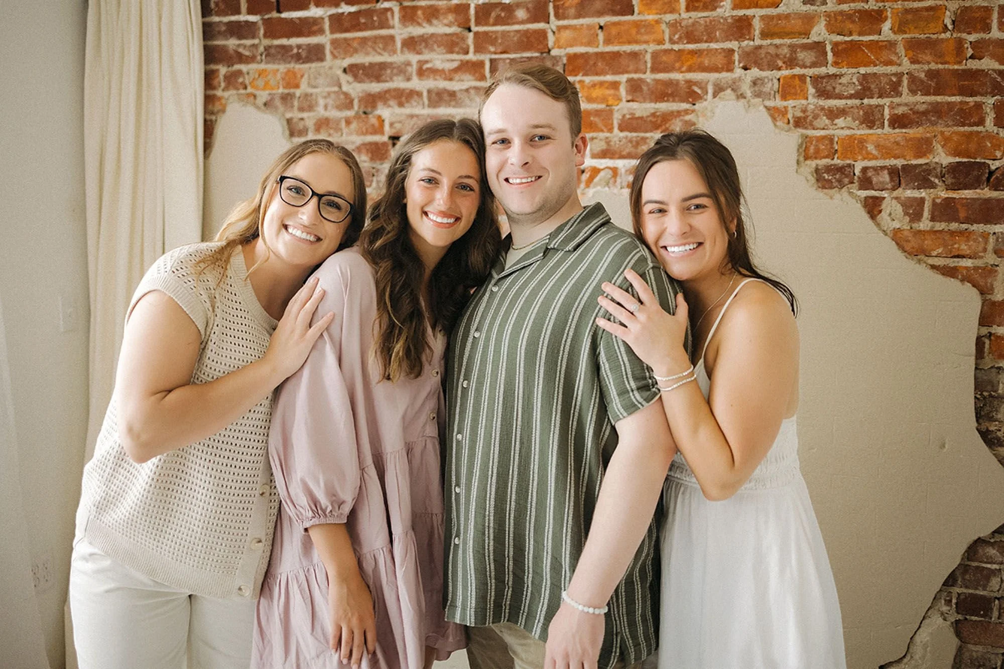 Warm and joyful family portrait featuring four loved ones smiling together during a studio photo session