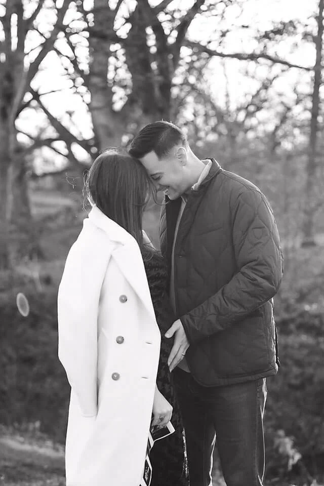 Golden Hour Fall Pregnancy Announcement Photos with the expecting couple leaning close beneath the fall trees, creating a quiet, emotional moment filled with anticipation for their little one.