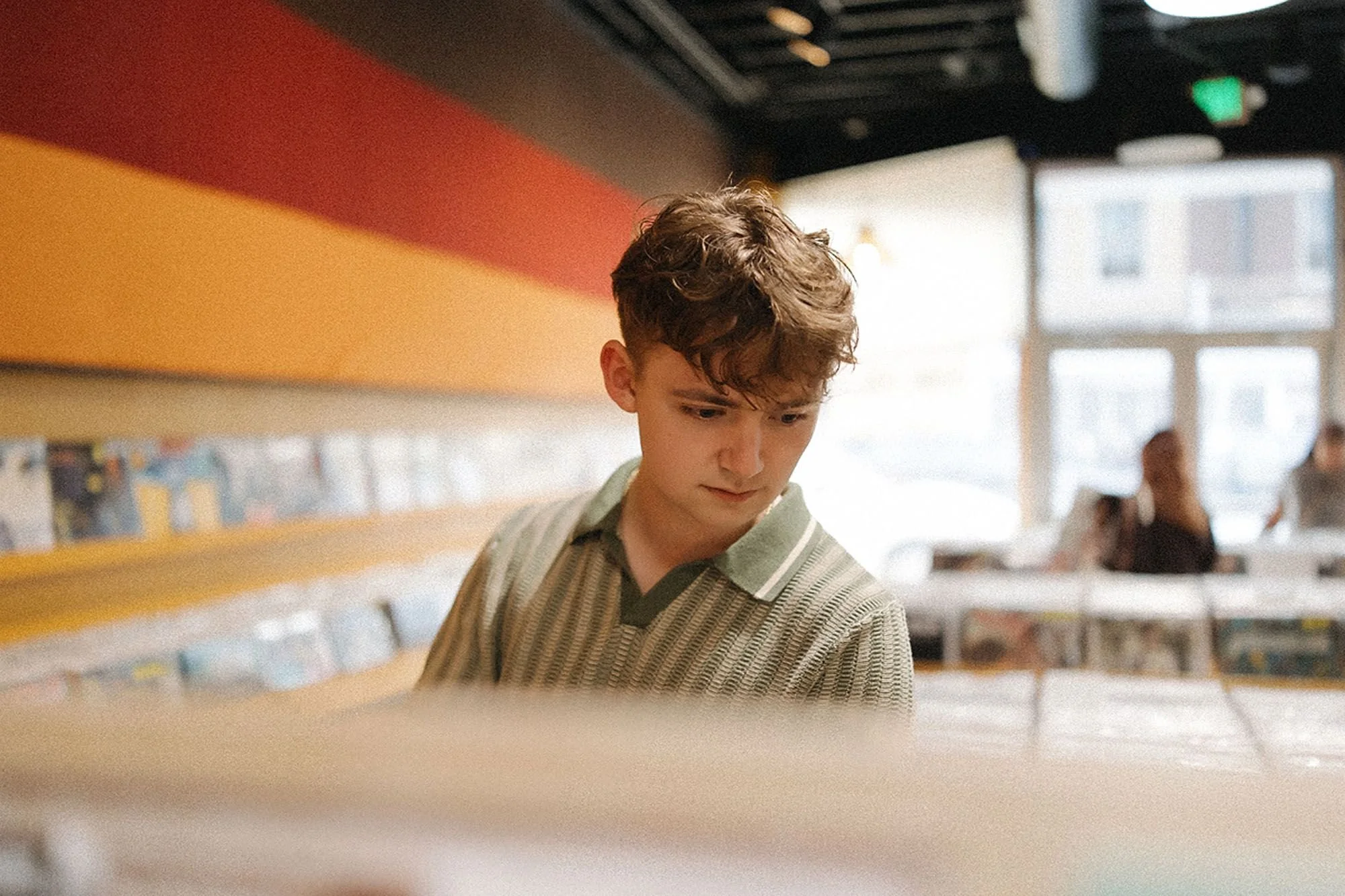 A young man examines a record in a store at Fountain Square, Indianapolis, surrounded by shelves of vinyl records