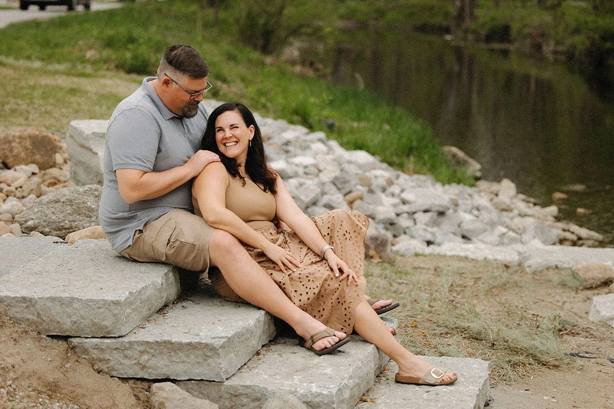 Parents smiling together during an outdoor portrait session, showing that a calm and joyful mood helps prepare kids for family photos naturally