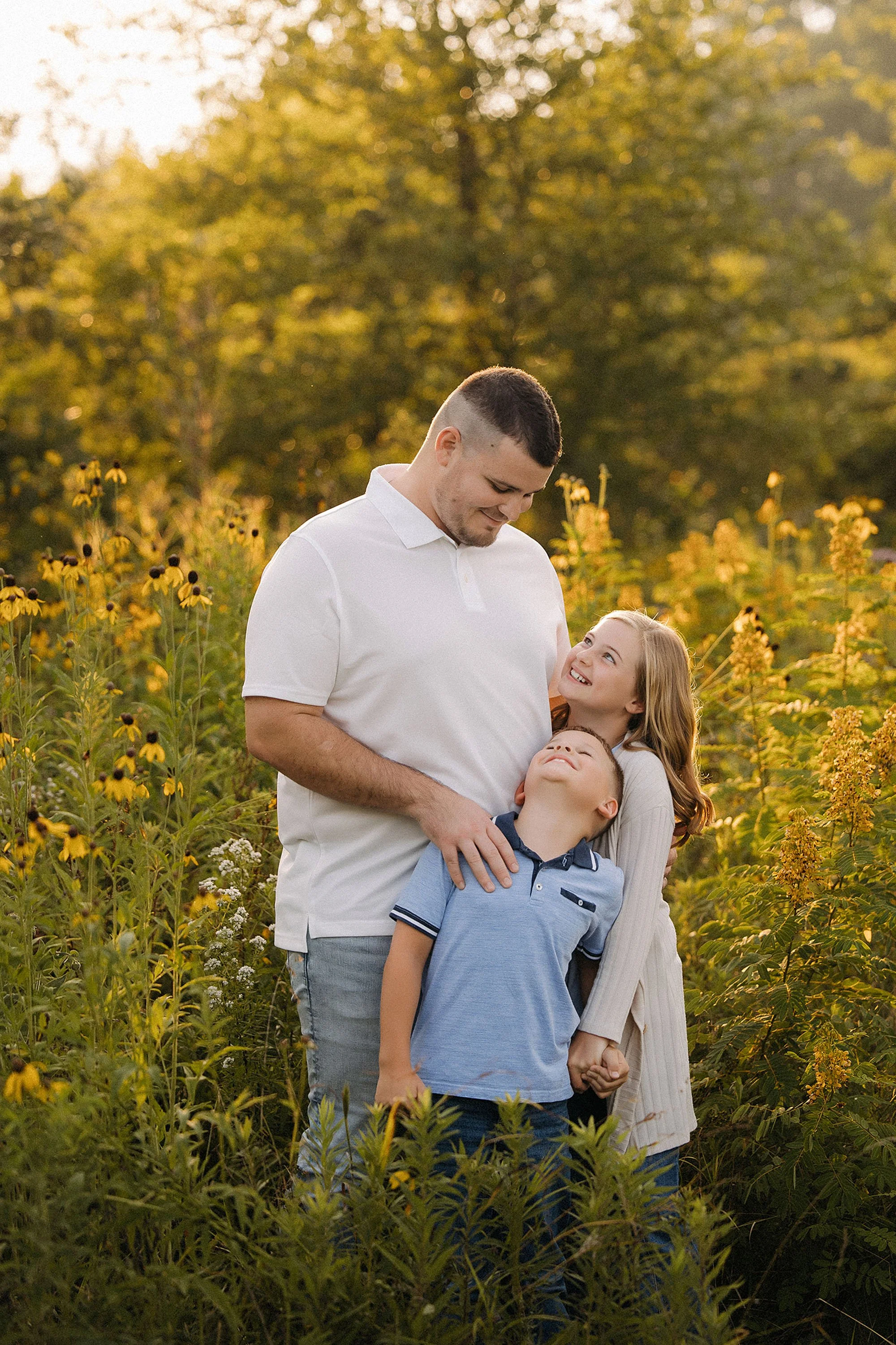 amily maternity photo with parents and two children surrounded by wildflowers at MacGregor Park in Westfield Indiana