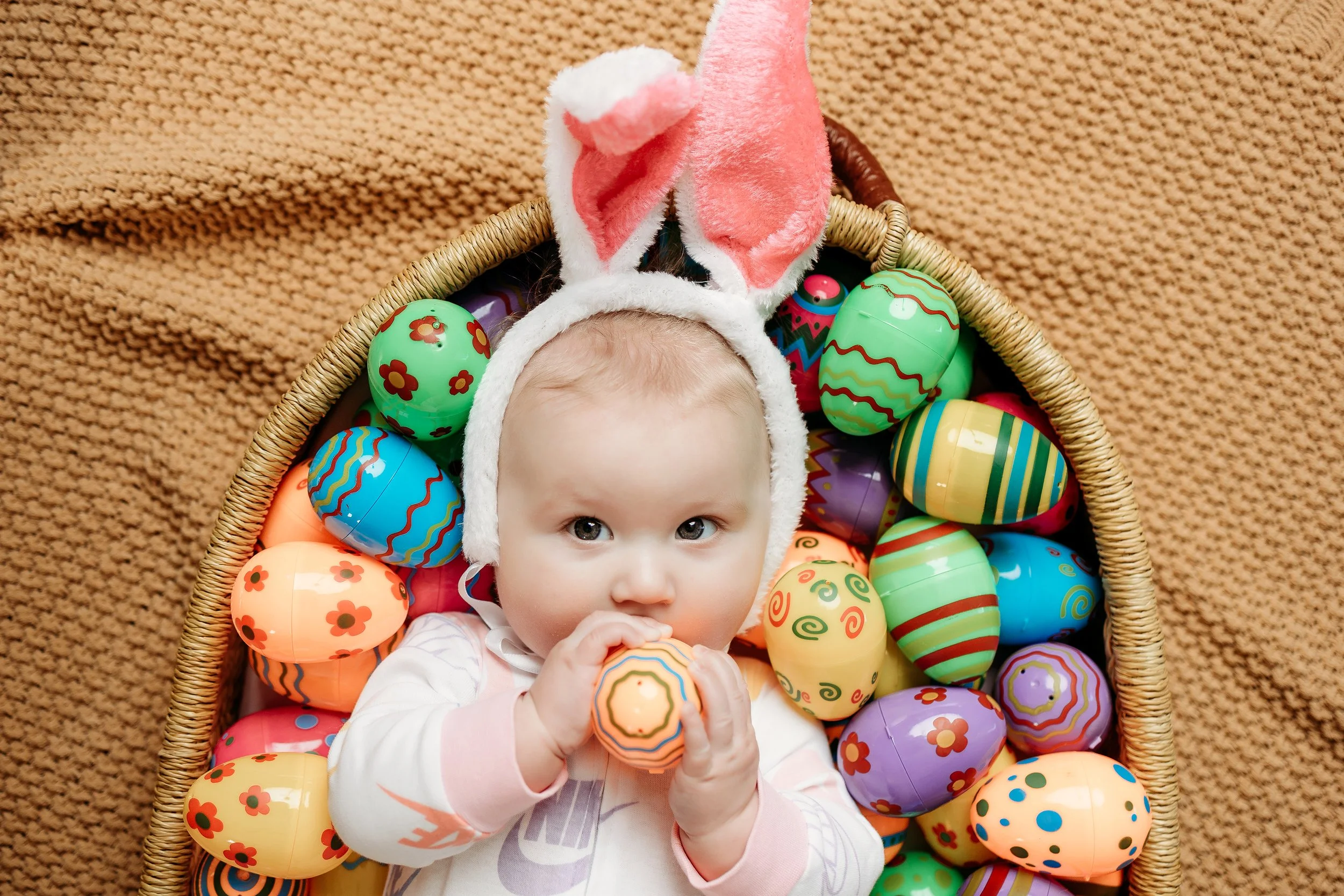 baby girl in a leopard print headband and white shirt, celebrating her 6-month milestone during a photoshoot