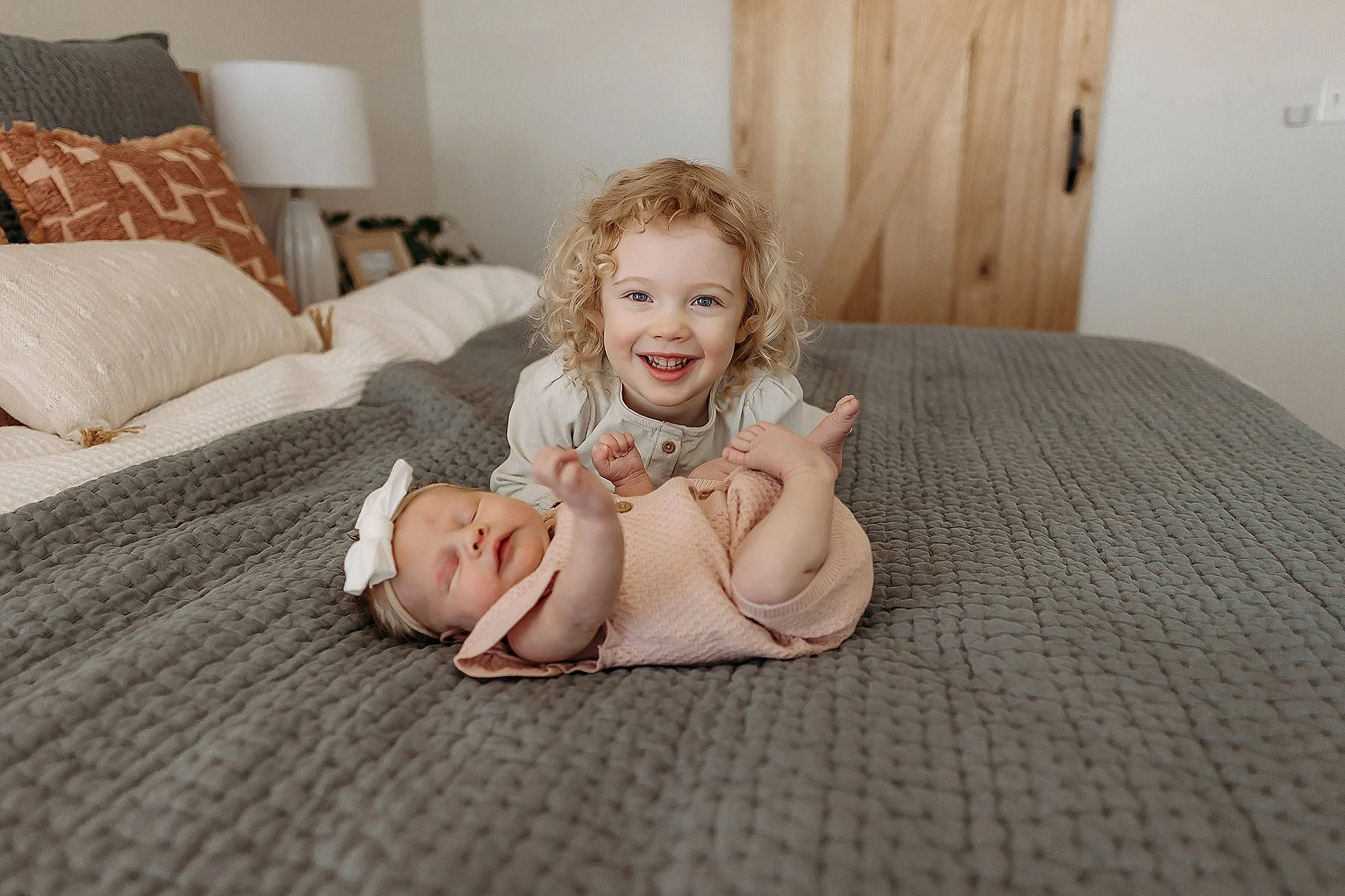 Newborn dressed in a simple gown during lifestyle newborn photos
